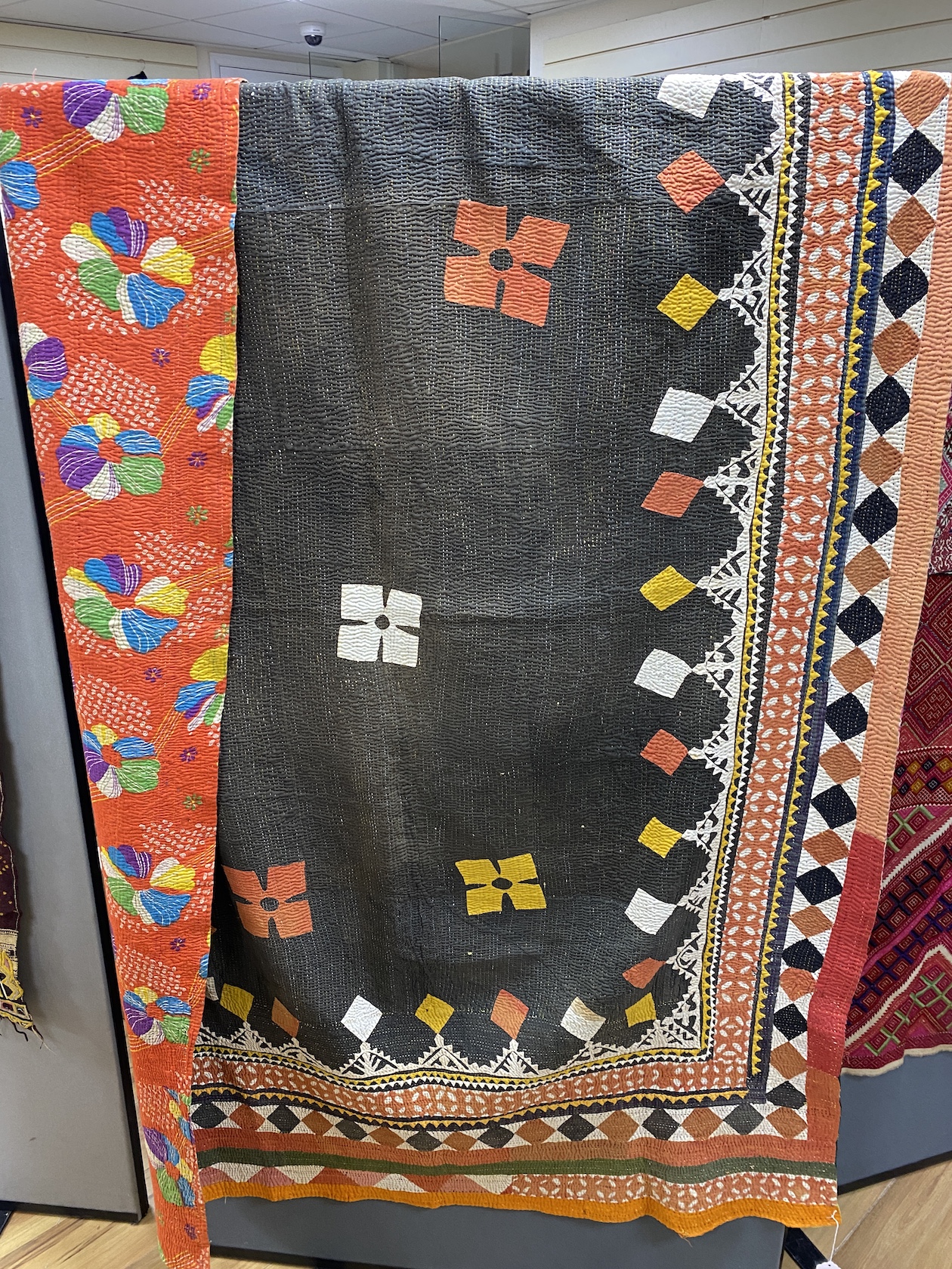 An early 20th century Indian multicoloured patchwork quilt, worked with a black central panel and ornate stripe bordered patterns, 140cm wide, 204cm long                                                                   