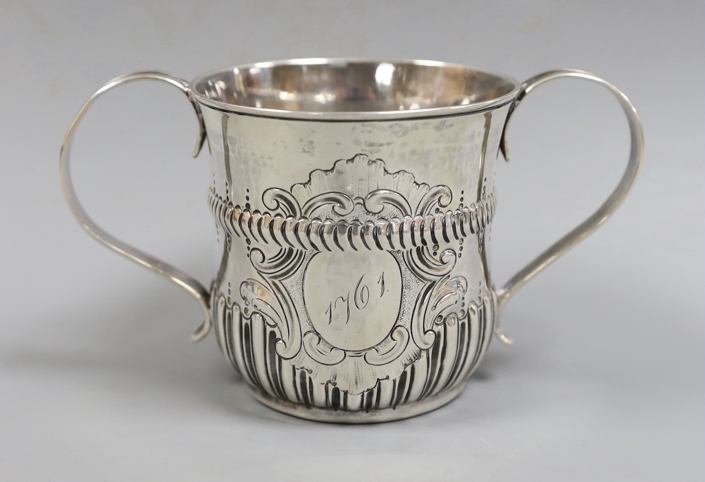 An early George III demi-fluted silver porringer, by John Moore, London, 1761, height 85mm, 7.2oz, with contemporary engraved date.                                                                                         