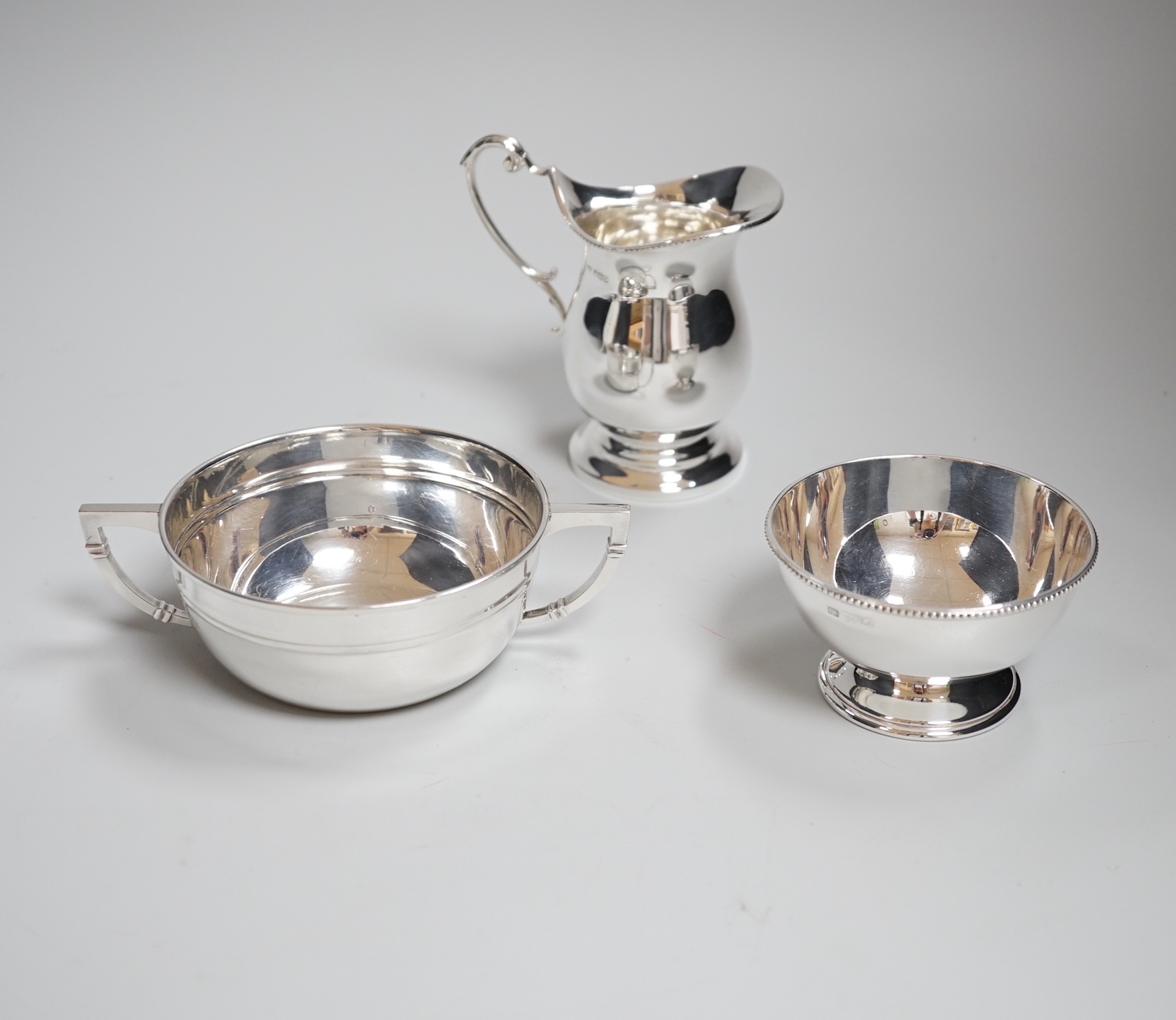 An Elizabeth II silver cream jug, with matching sugar bowl, Sheffield 1968, 225 grams, and a James Dixon & Sons two handled bowl, Sheffield 1943, 139 grams                                                                 