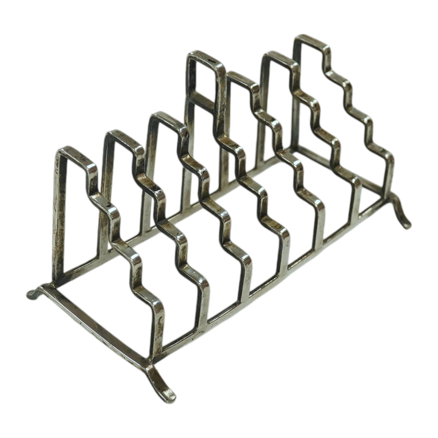 An unusual George V stepped silver seven bar toast rack, by A L Davenport Ltd, Birmingham, 1938, length 13.4cm. Condition - fair                                                                                            