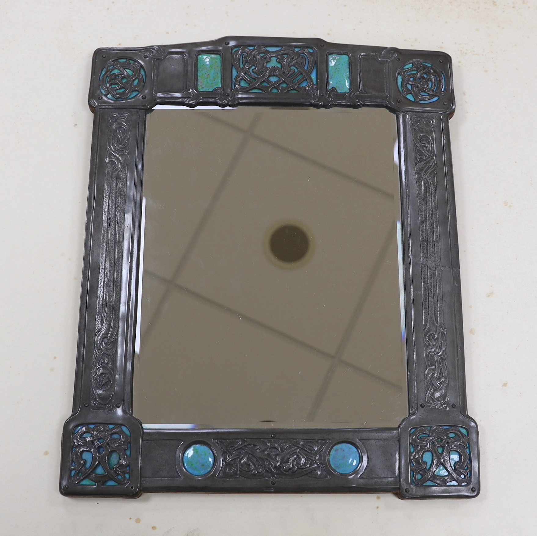 A Miller Brothers Art Nouveau embossed pewter mirror with cabochon turquoise enamel bosses, 48cm high x 39cm wide                                                                                                           