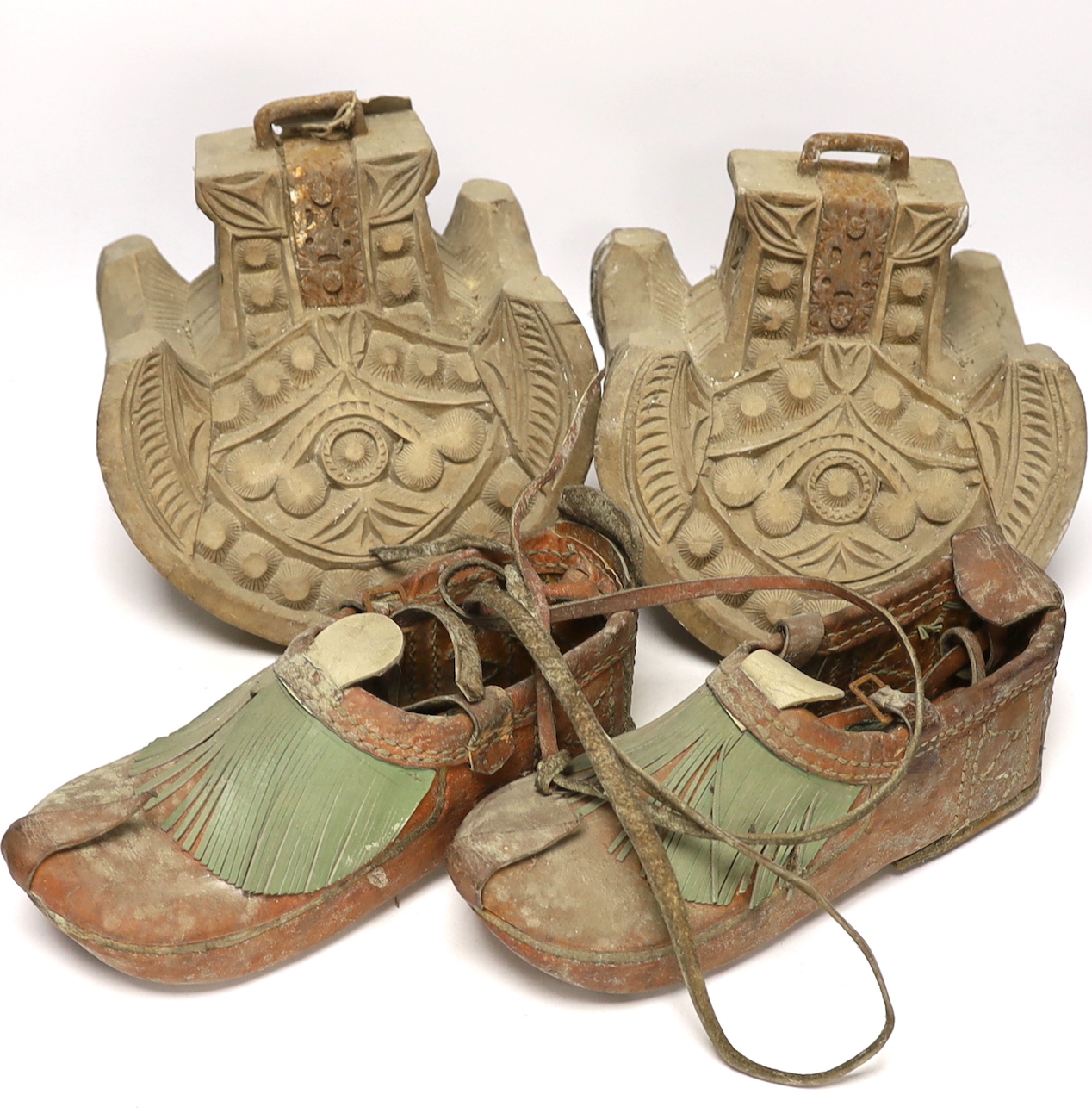 A pair of Spanish-Colonnial carved wood stirrups and a pair of Indian leather shoes                                                                                                                                         