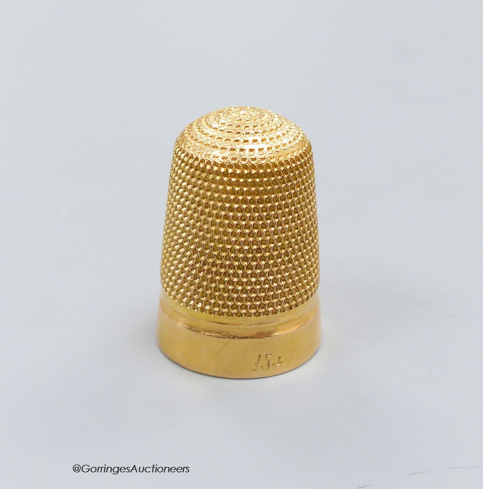 A 15ct. gold thimble with 1910 inscription, 6.4g.                                                                                                                                                                           