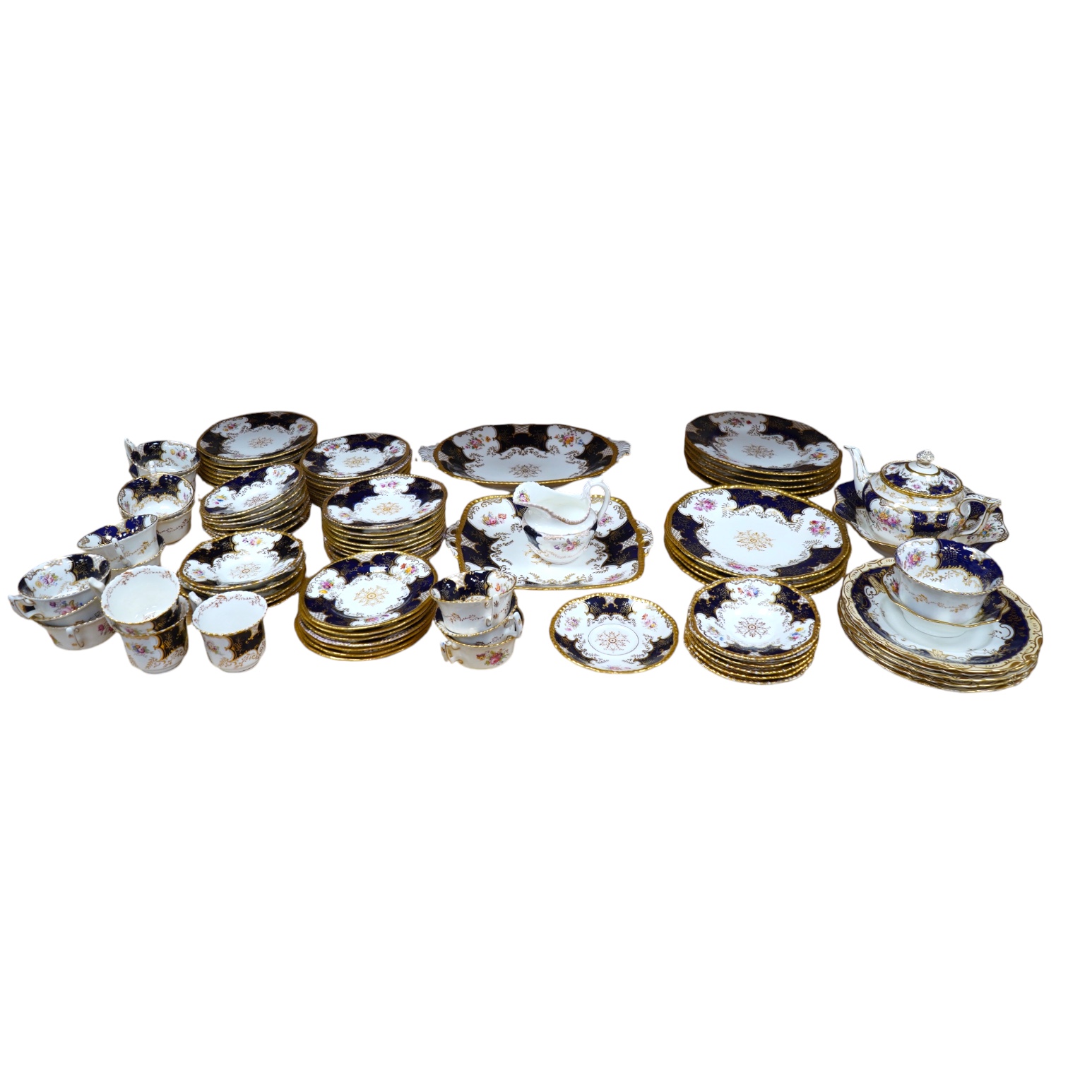 A late 19th/early 20th century Coalport blue and gilt bordered floral painted part tea and dessert service, largest 32cm wide. Condition - varies                                                                           