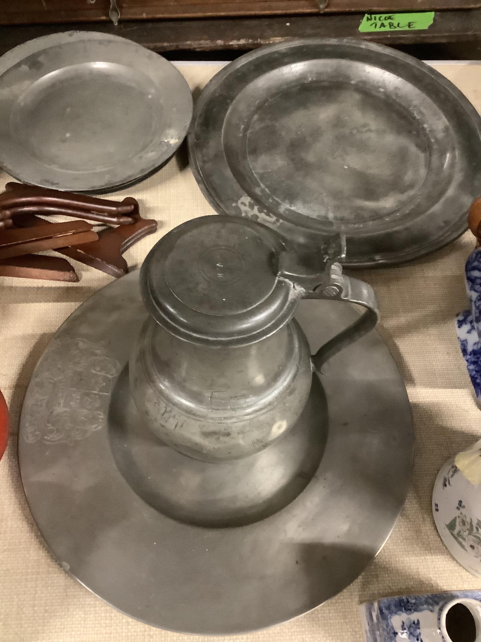 Two pewter chargers one crested, eight plates and a jug, 18th century and later, largest charger 38cms diameter                                                                                                             