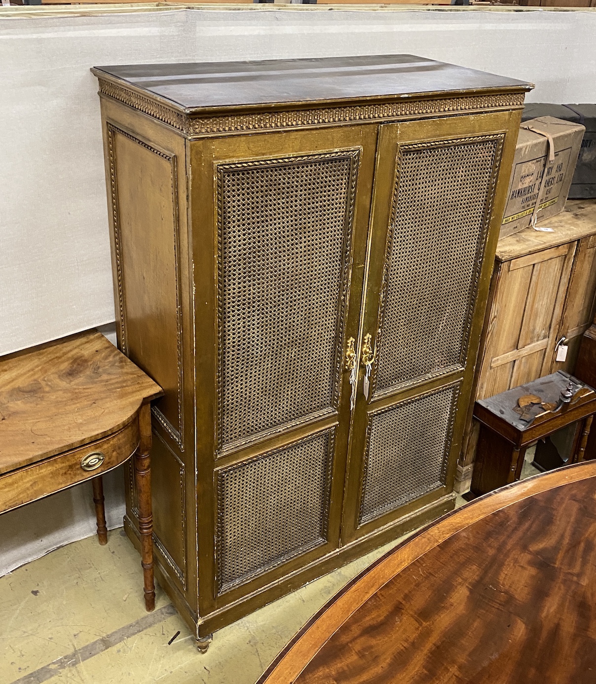 A gilt painted caned two door wardrobe, width 111cm, depth 56cm, height 168cm                                                                                                                                               