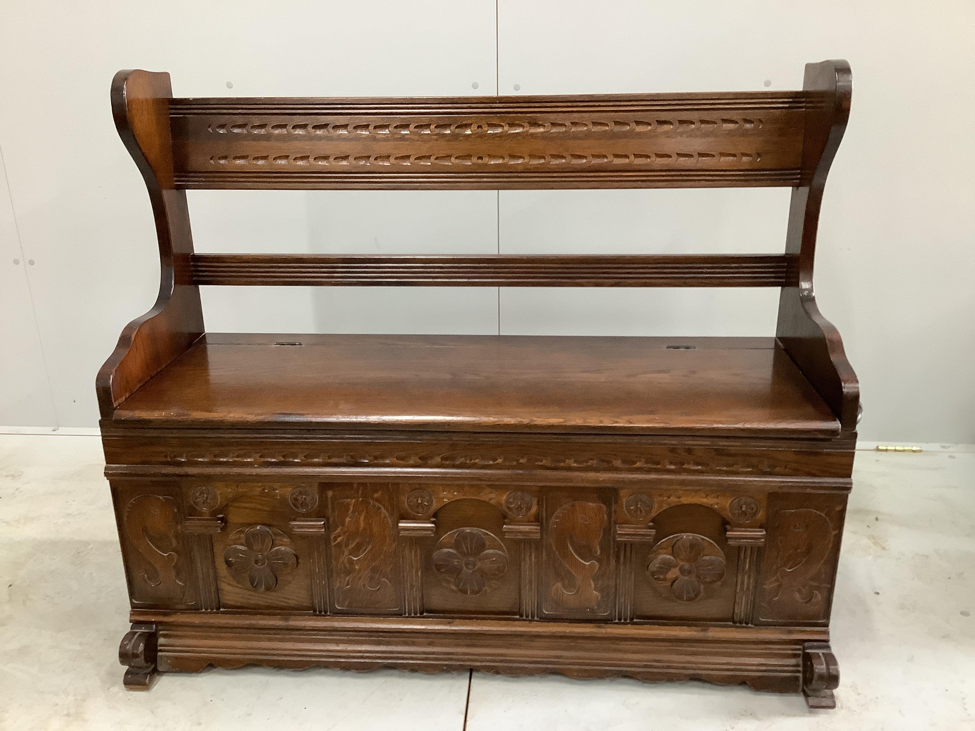 An 18th century style carved oak settle, with hinged box seat, width 115cm, depth 40cm, height 98cm                                                                                                                         