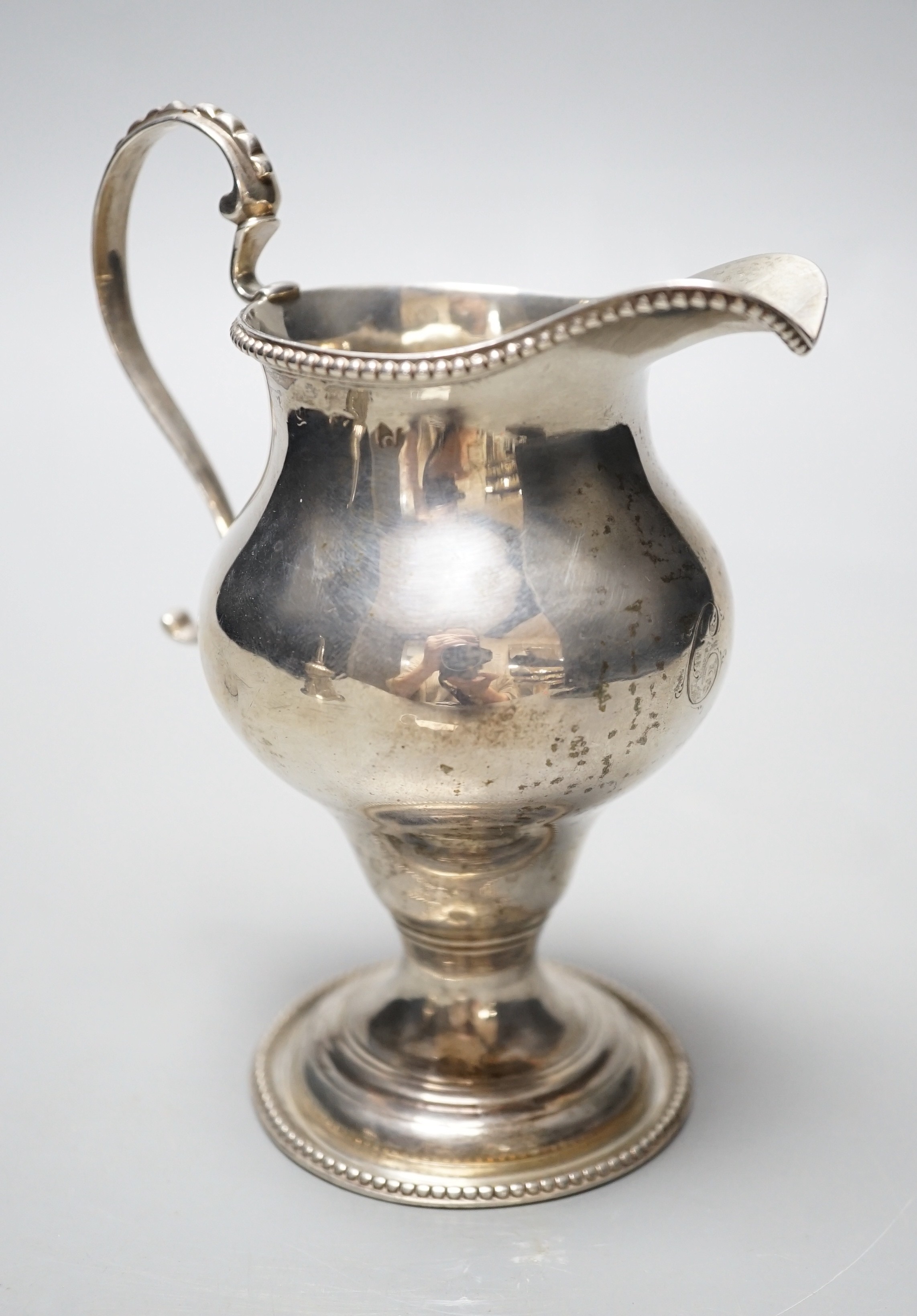 A George III silver inverted pear shaped cream jug, London, 1779, 31.1cm, maker's mark rubbed.                                                                                                                              
