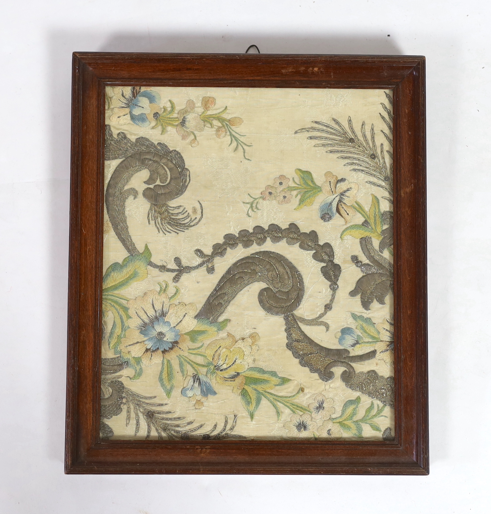A framed 18th century French silk damask embroidered panel possibly a fragment from Chasuble or similar religious garment. Embroidered in floral and scrolling design, using polychrome silks and metallic threads, 27cm x 2