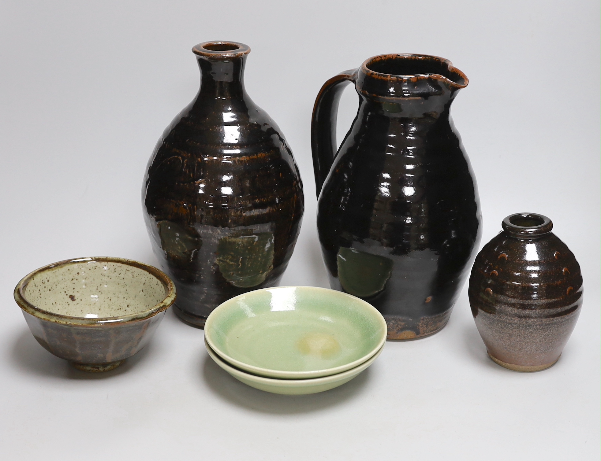 Two green glazed dishes by Jack Kenny, two dark glazed vases, a similar jug and a small bowl, tallest 26cm high                                                                                                             