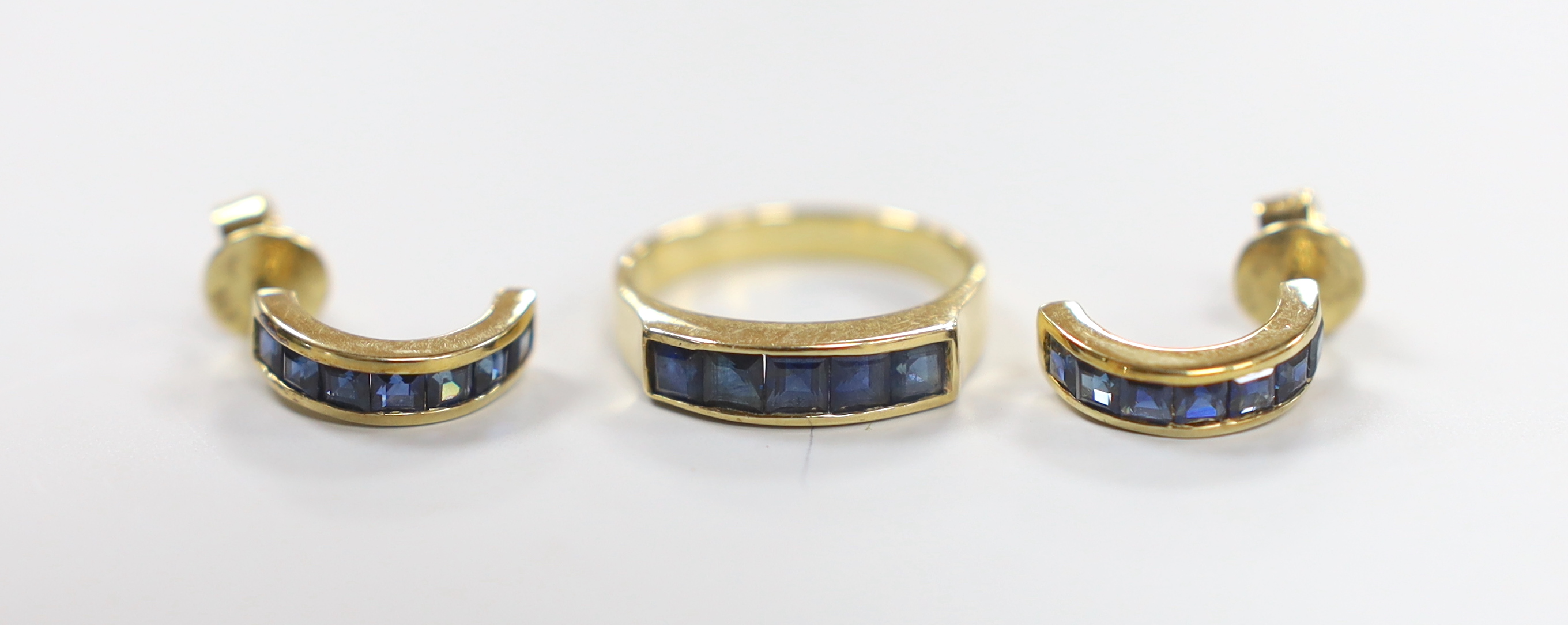 A modern 585 yellow metal and five stone channel set sapphire half hoop ring, size N and a pair of matching half hoop earrings, gross weight 7.5 grams.                                                                     