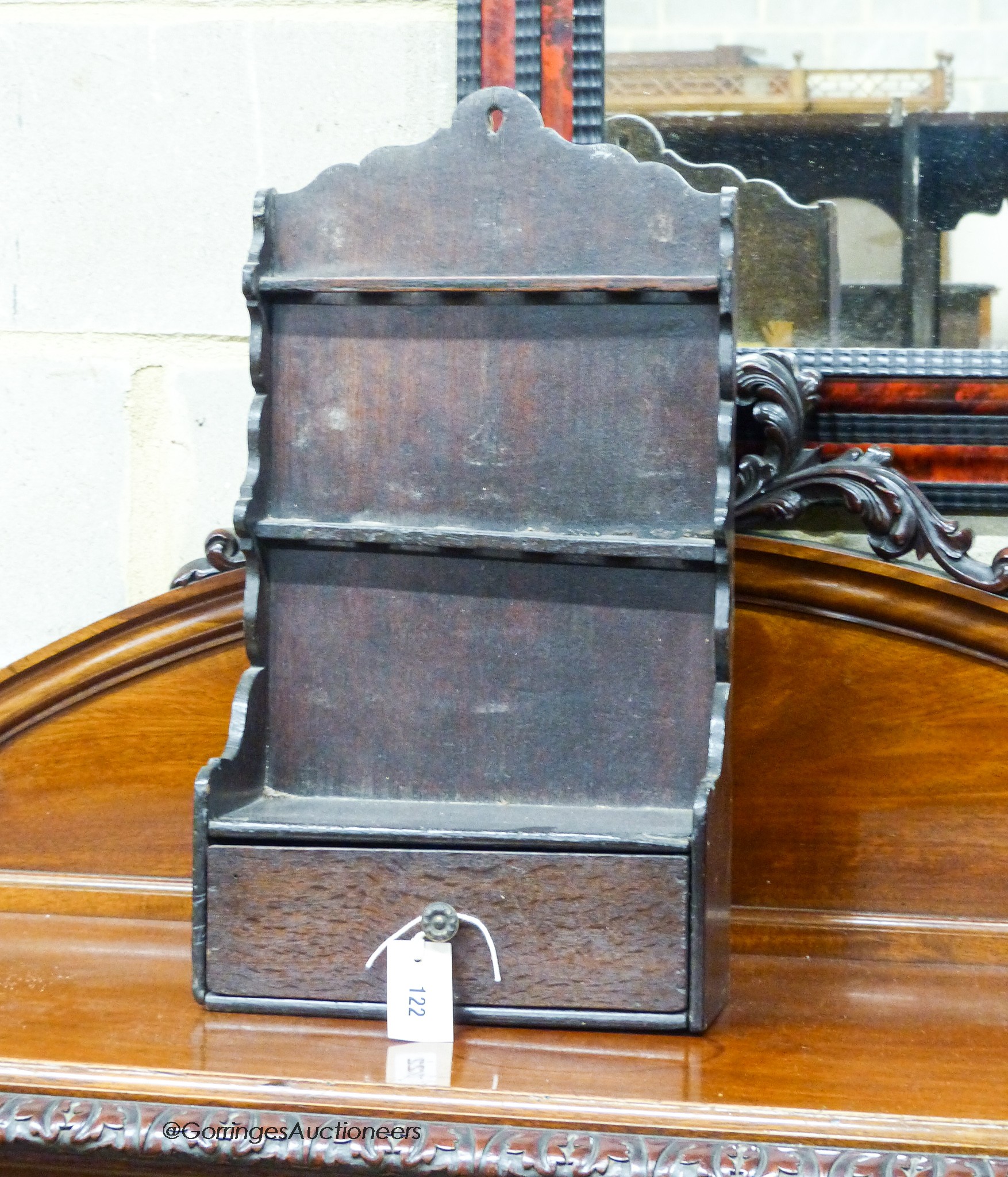 An 18th century oak spoon rack, of shaped outline with drawer below, width 29cm, depth 13cm, height 54cm                                                                                                                    