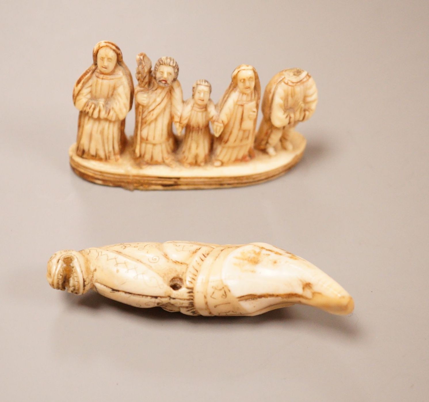 An Inuit whale tooth carving, 19th century, 8cm long, and a marine ivory religious group, possibly Goa                                                                                                                      