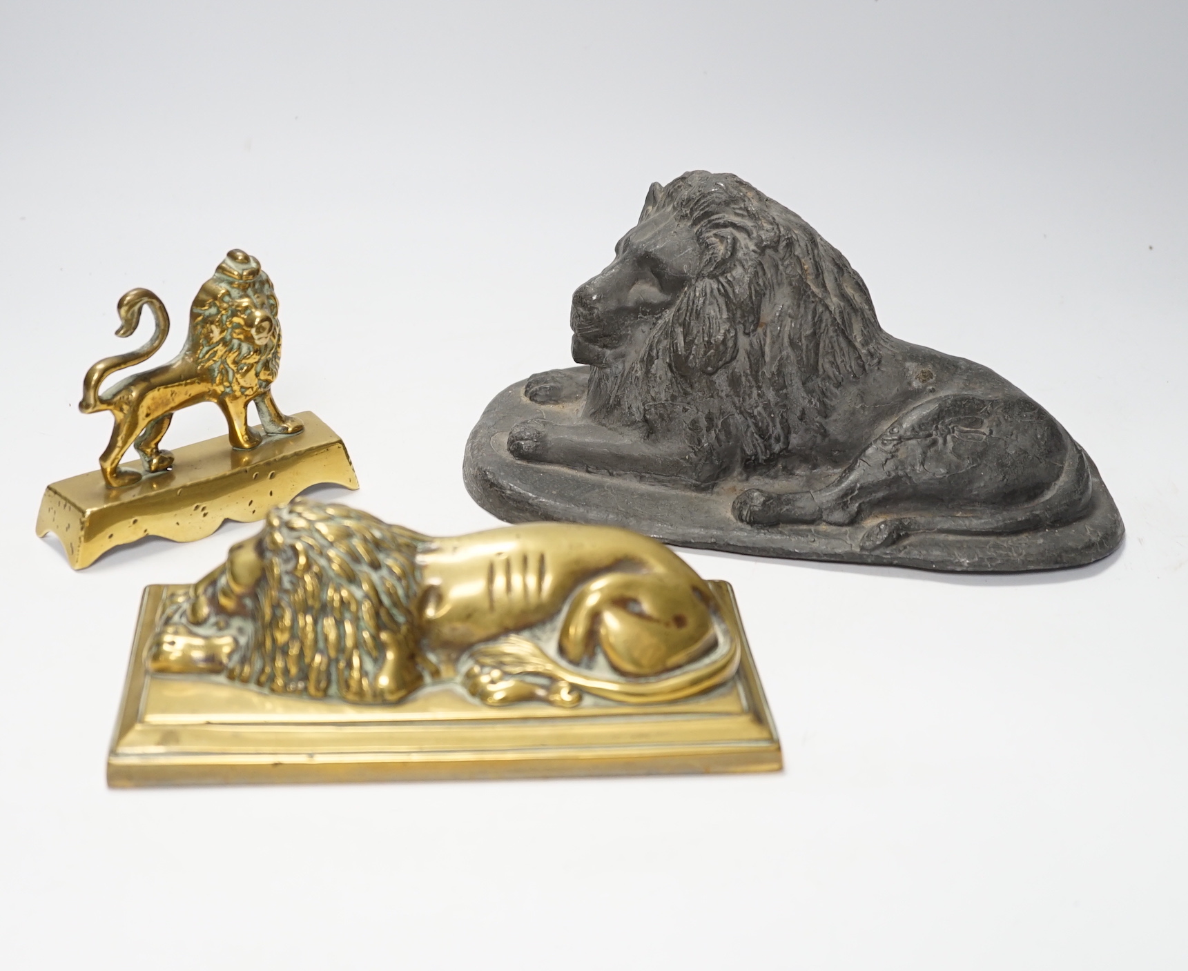 A 19th century brass recumbent lion, a similar cast iron lion and a smaller lion, largest 22cm wide                                                                                                                         