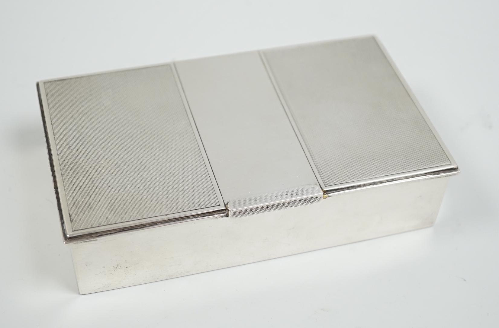 A George VI part engine turned silver mounted cigarette box, London, 1951, 16.5cm.                                                                                                                                          