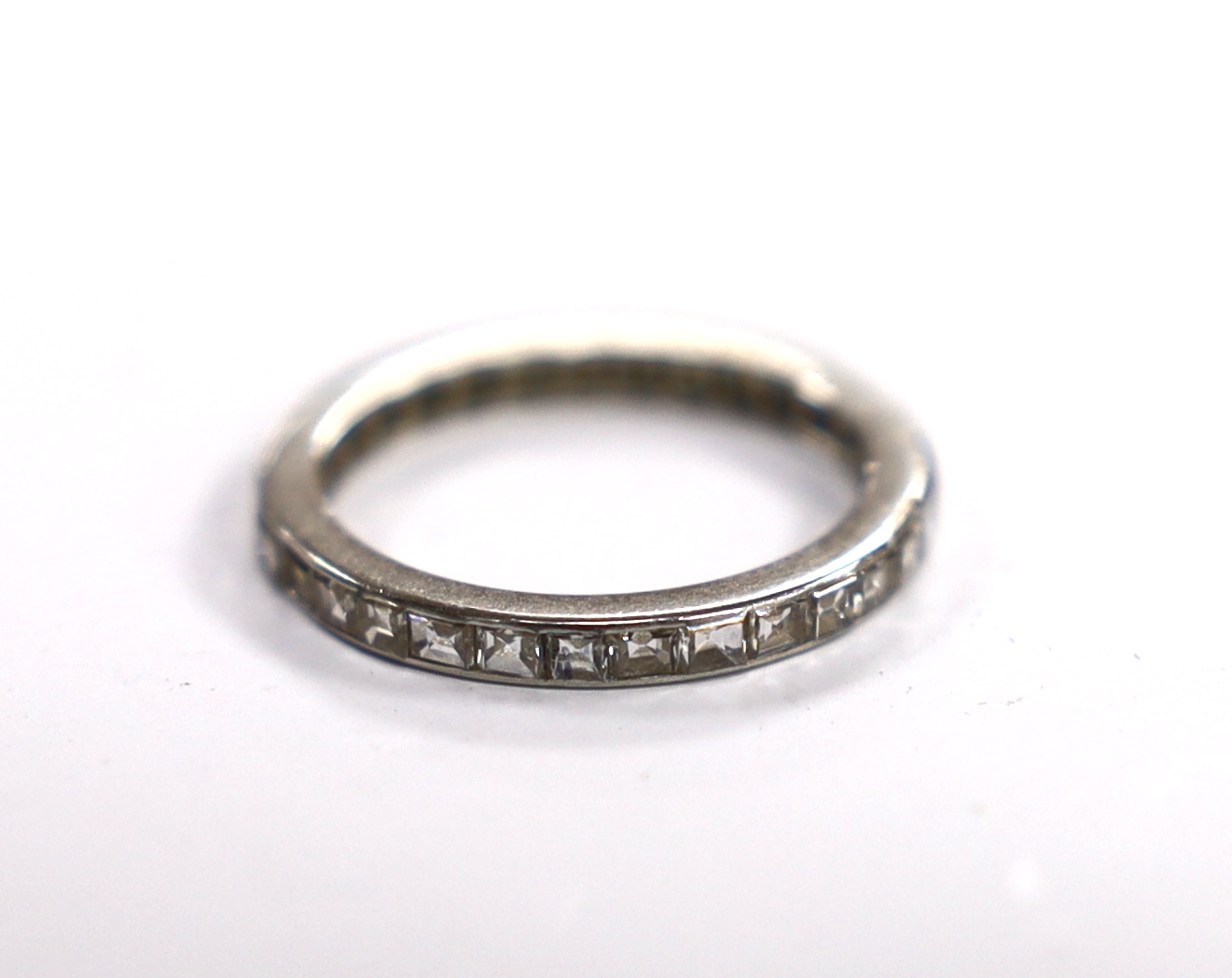 A white metal and channel set diamond full eternity ring, size J, gross weight 2.2 grams.                                                                                                                                   