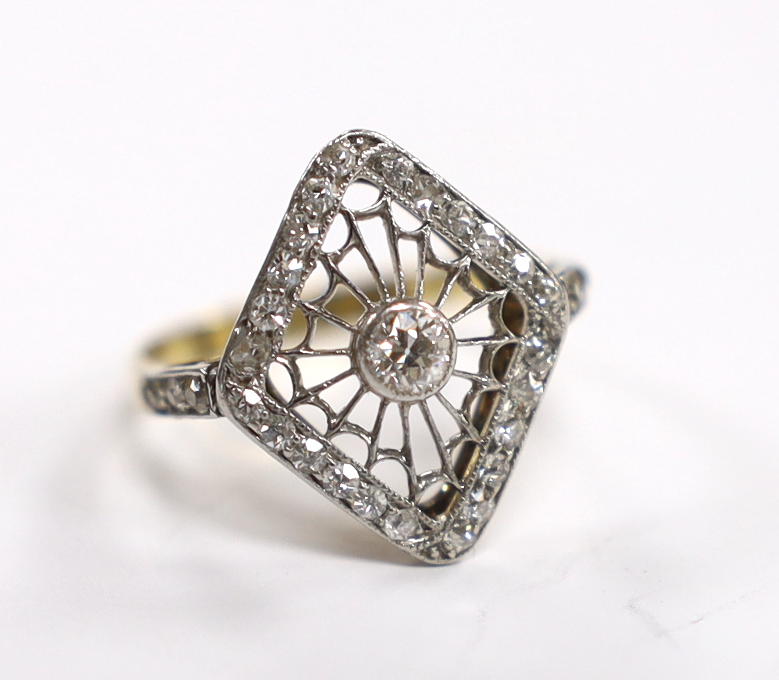 An 18ct, plat and diamond cluster set diamond ring, of diamond shape with pierced 'spider's web' centre, size J/K, gross weight 2.4 grams.                                                                                  