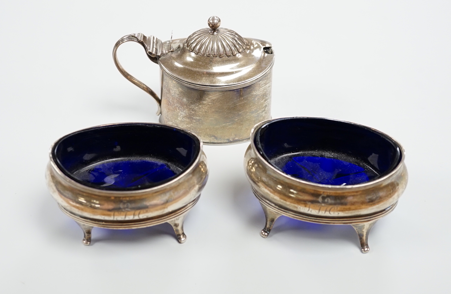 A pair of George III silver oval salts, on splayed legs, Soloman Hougham, London, 1812, length 89mm, together with a George III silver oval mustard pot, Abstinando King, London, 1797.                                     