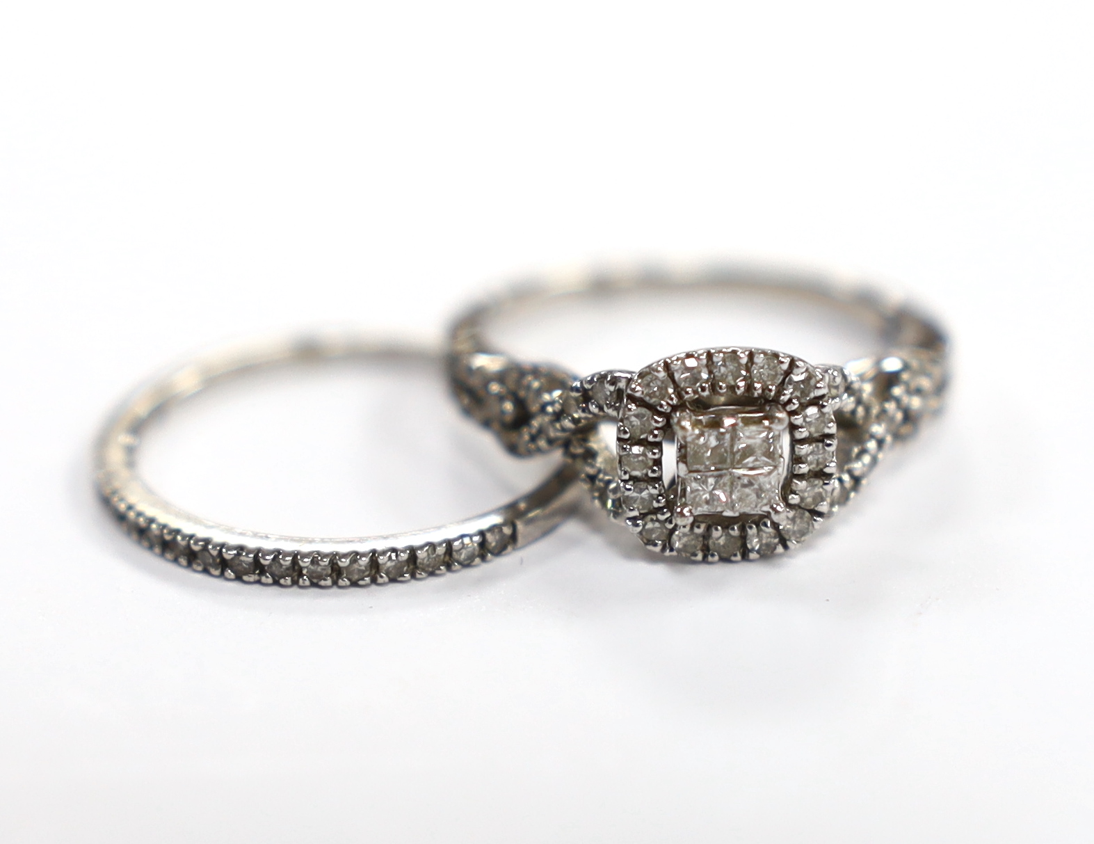 A modern white metal and diamond set cluster ring, with diamond set shoulders size N and a similar diamond chip set half eternity ring, engraved 'Plat', size N, gross weight 4.2 grams.                                    
