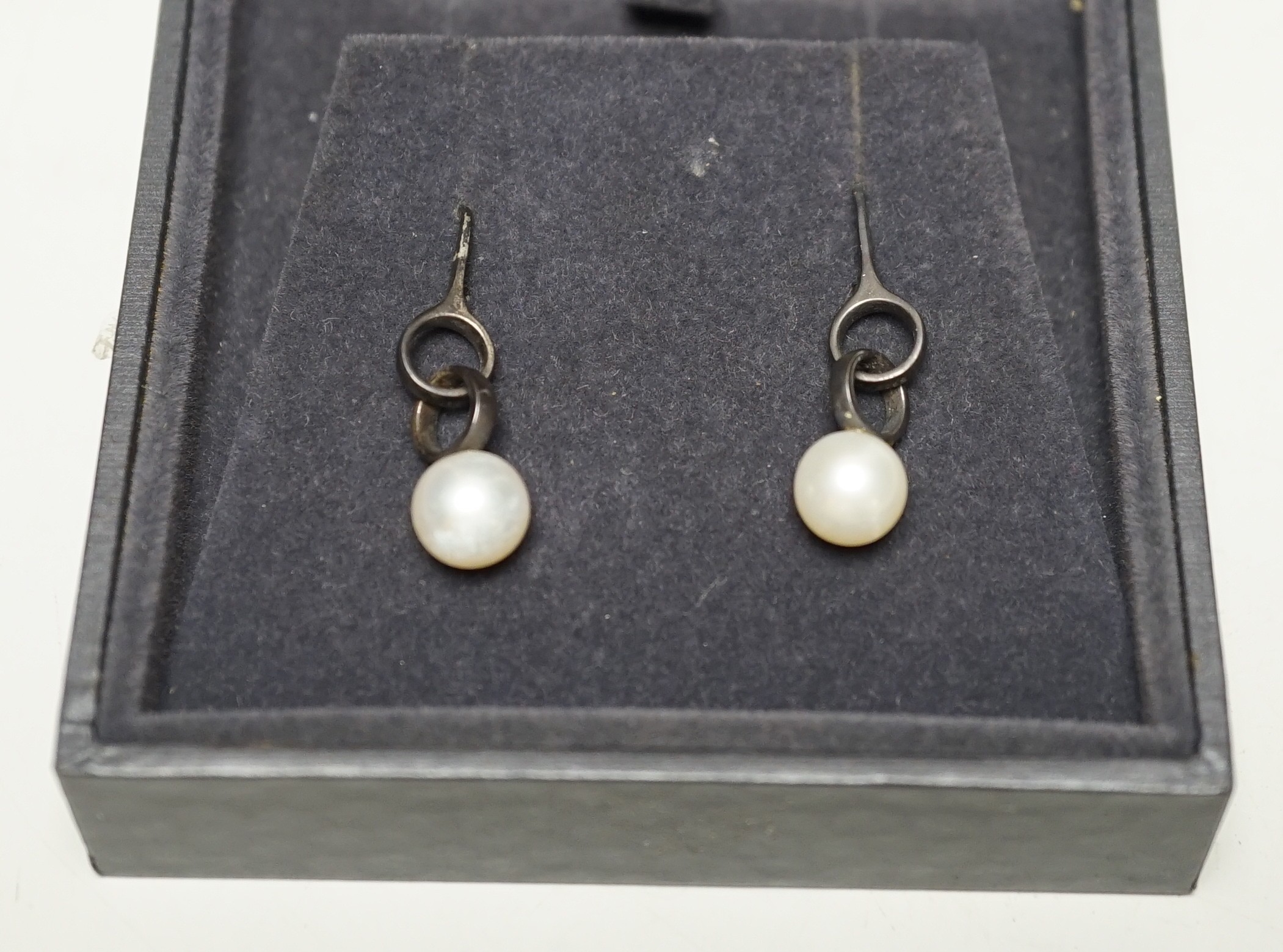 A modern pair of Georg Jensen silver and cultured pearl set drop earrings, 31mm, in Georg Jensen box.                                                                                                                       