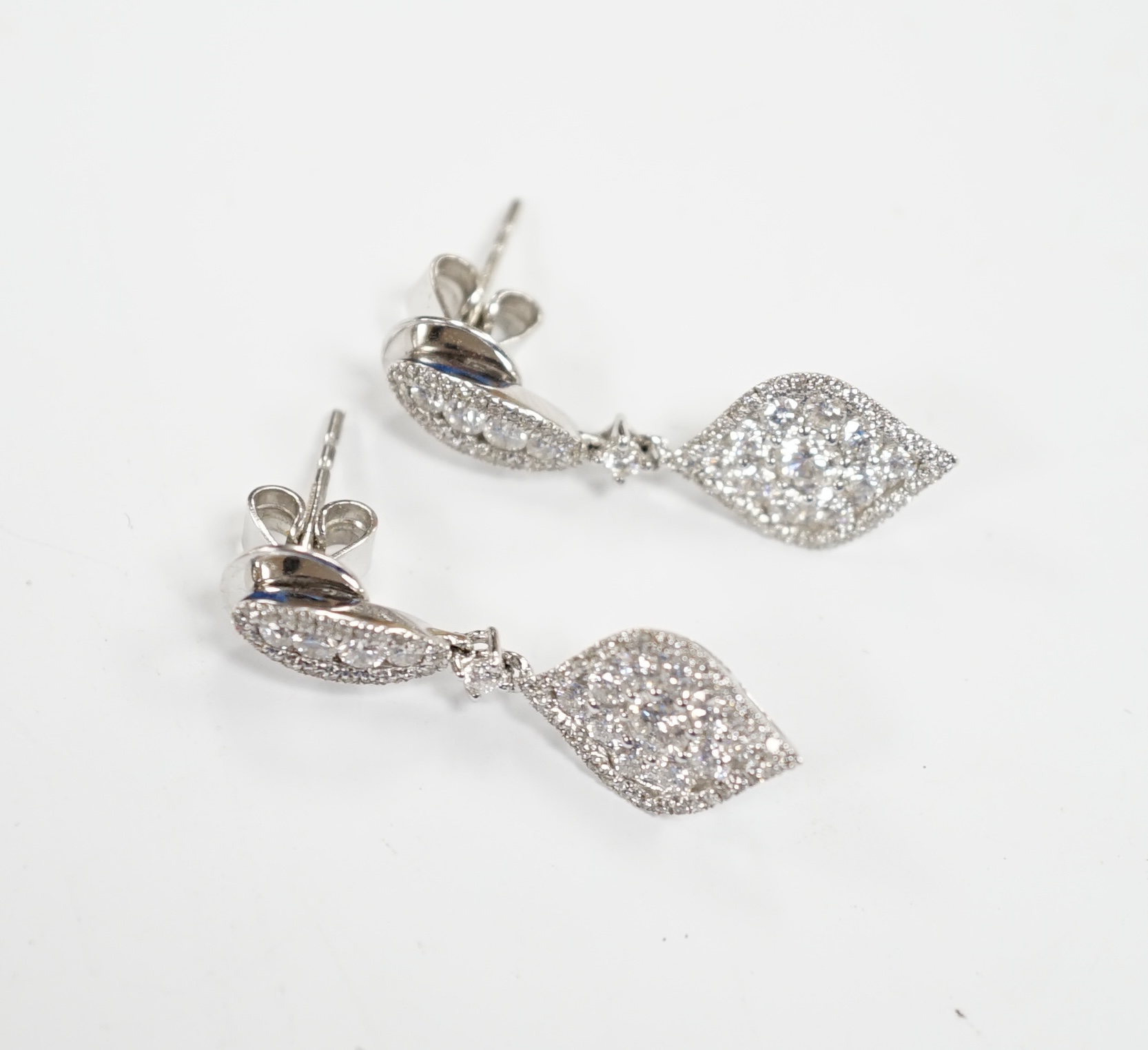 A modern pair of 750 white metal and diamond cluster set drop earrings, of elliptical form, 26mm, gross weight 4.1 grams.                                                                                                   