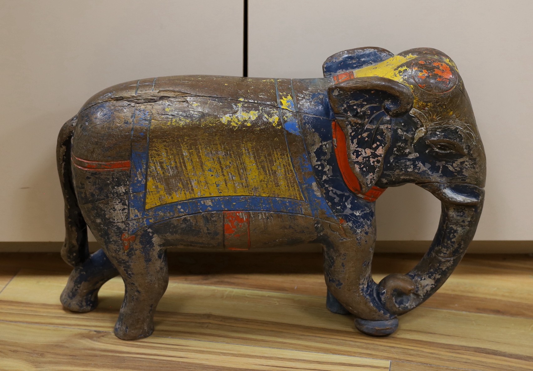 A large painted Indian hardwood elephant. 63cm wide                                                                                                                                                                         