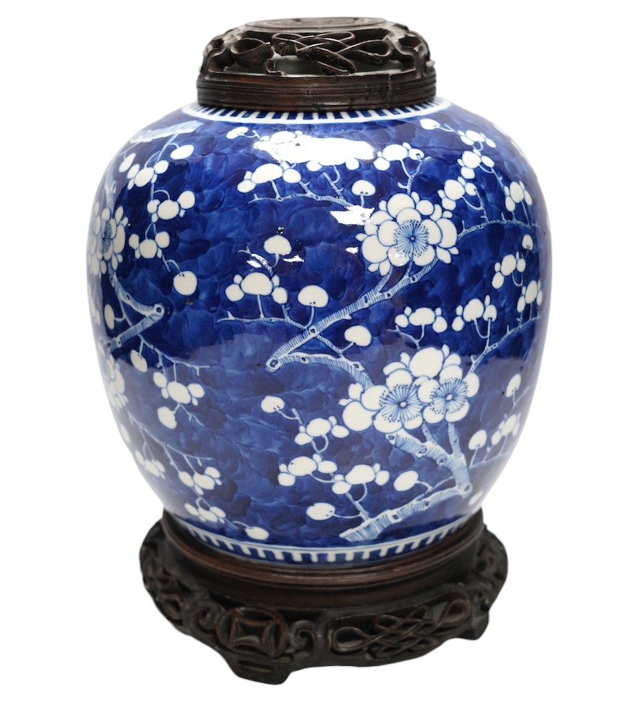 A 19th century Chinese blue and white ginger jar with hardwood stand and cover, overall 30cm high. Condition - jar and stand good, cover repaired                                                                           