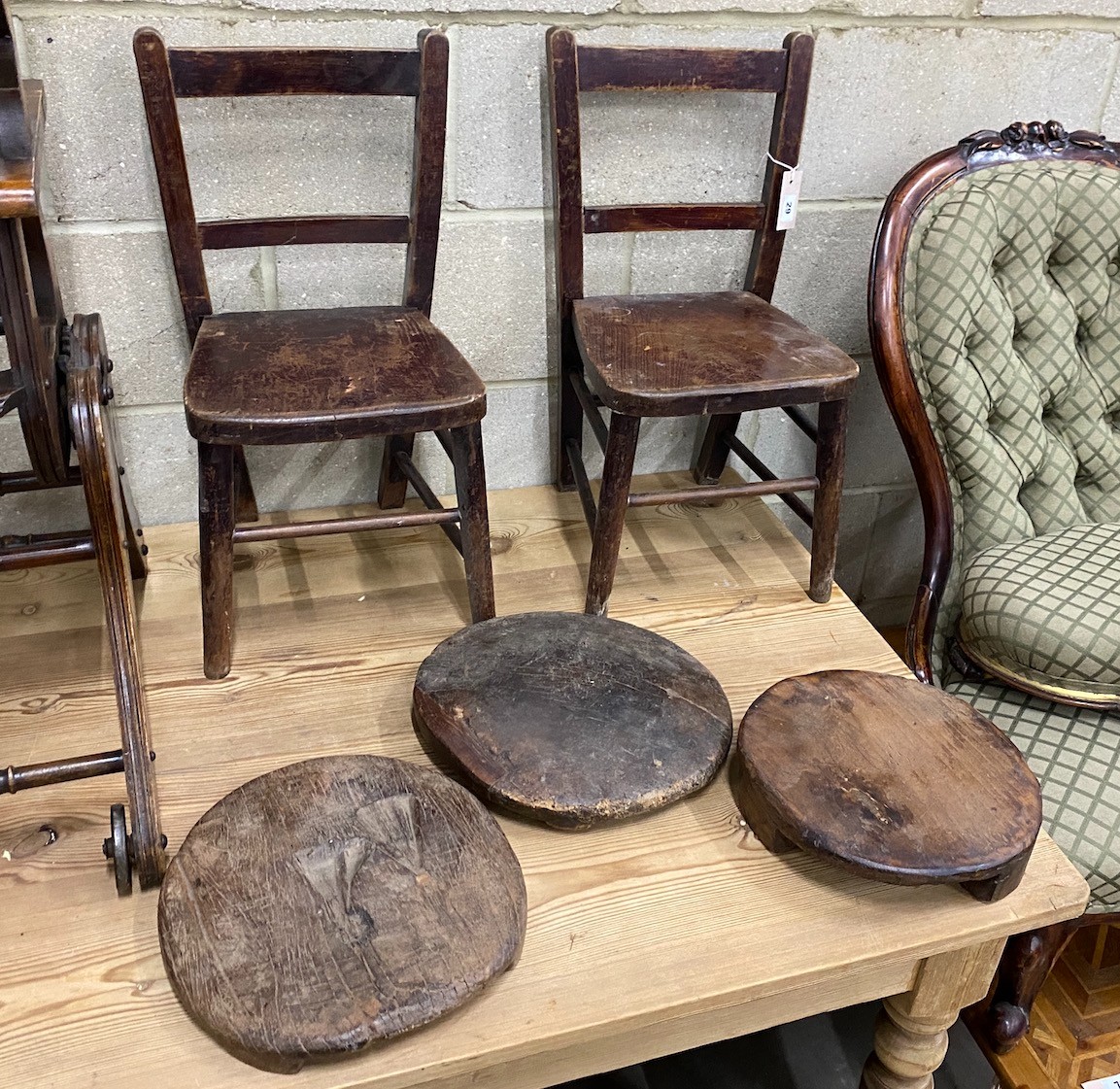 A pair of early 20th century elm and beech childs chairs and three African trivets                                                                                                                                          