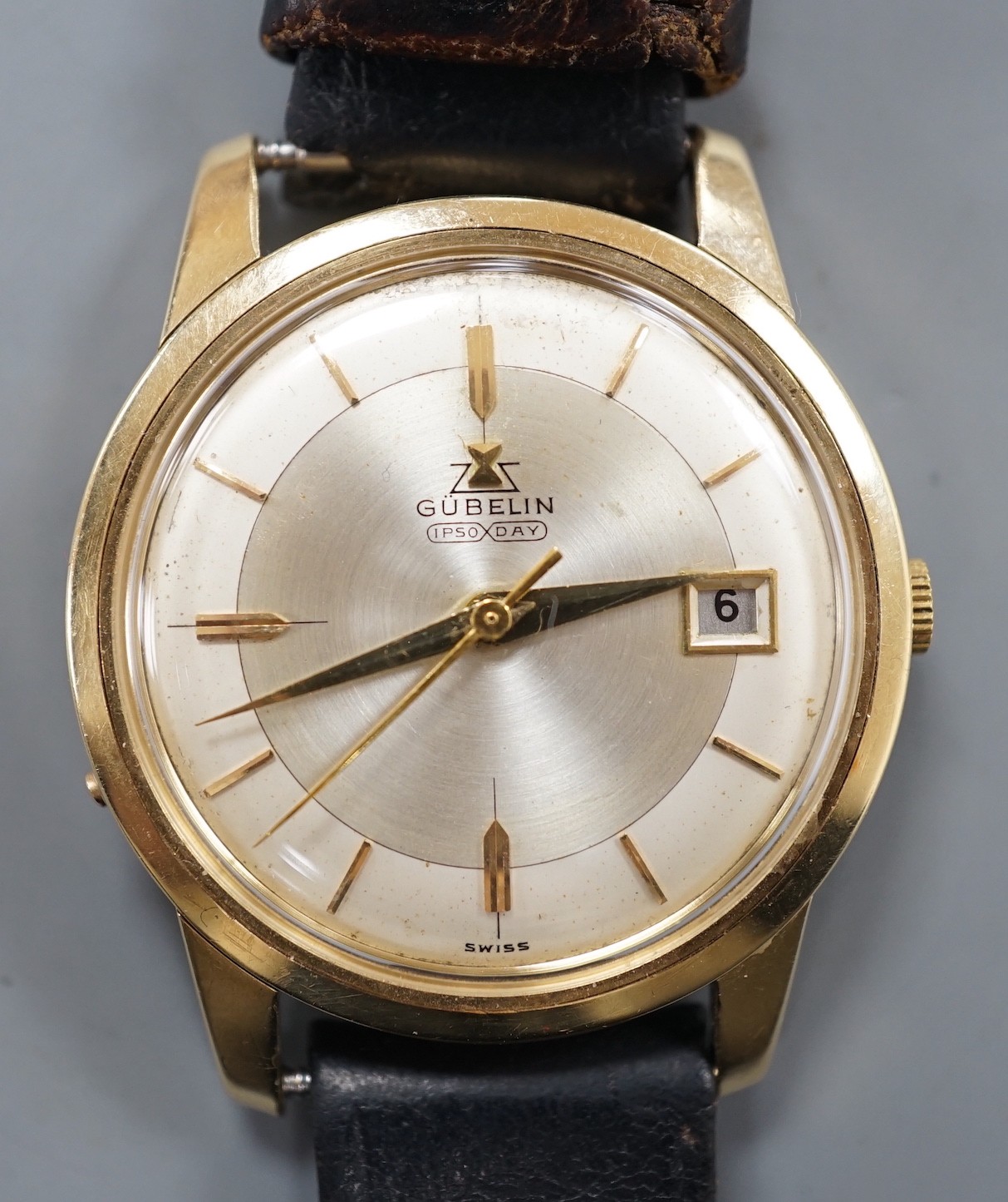 A gentleman's 14ct gold Gubelin Ipso Day automatic wrist watch, with baton numerals and date aperture, on associated leather strap, the case back with engraved initials, case diameter 35mm                                