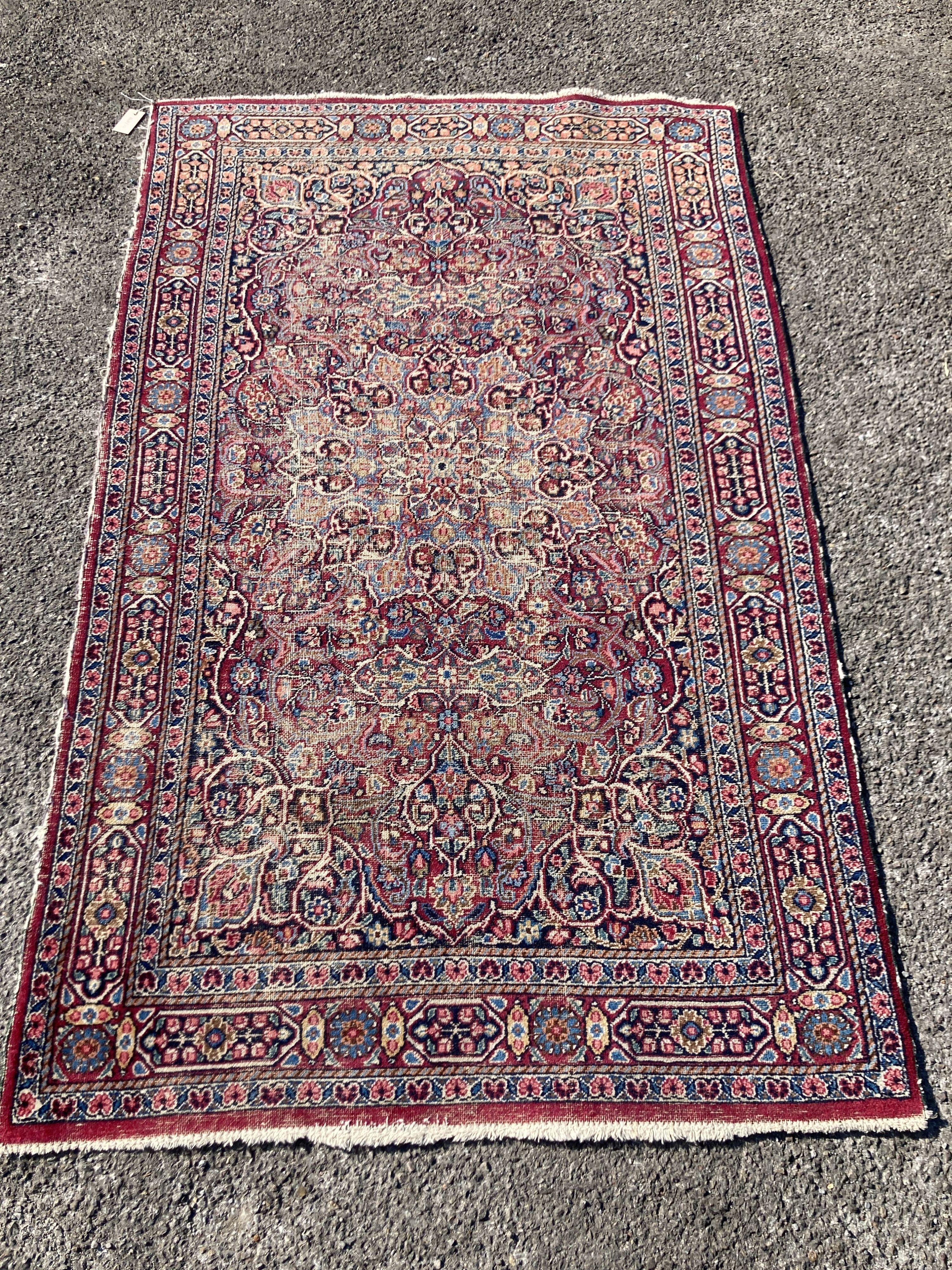 A North West Persian red ground rug (worn), 127 x 76cm                                                                                                                                                                      