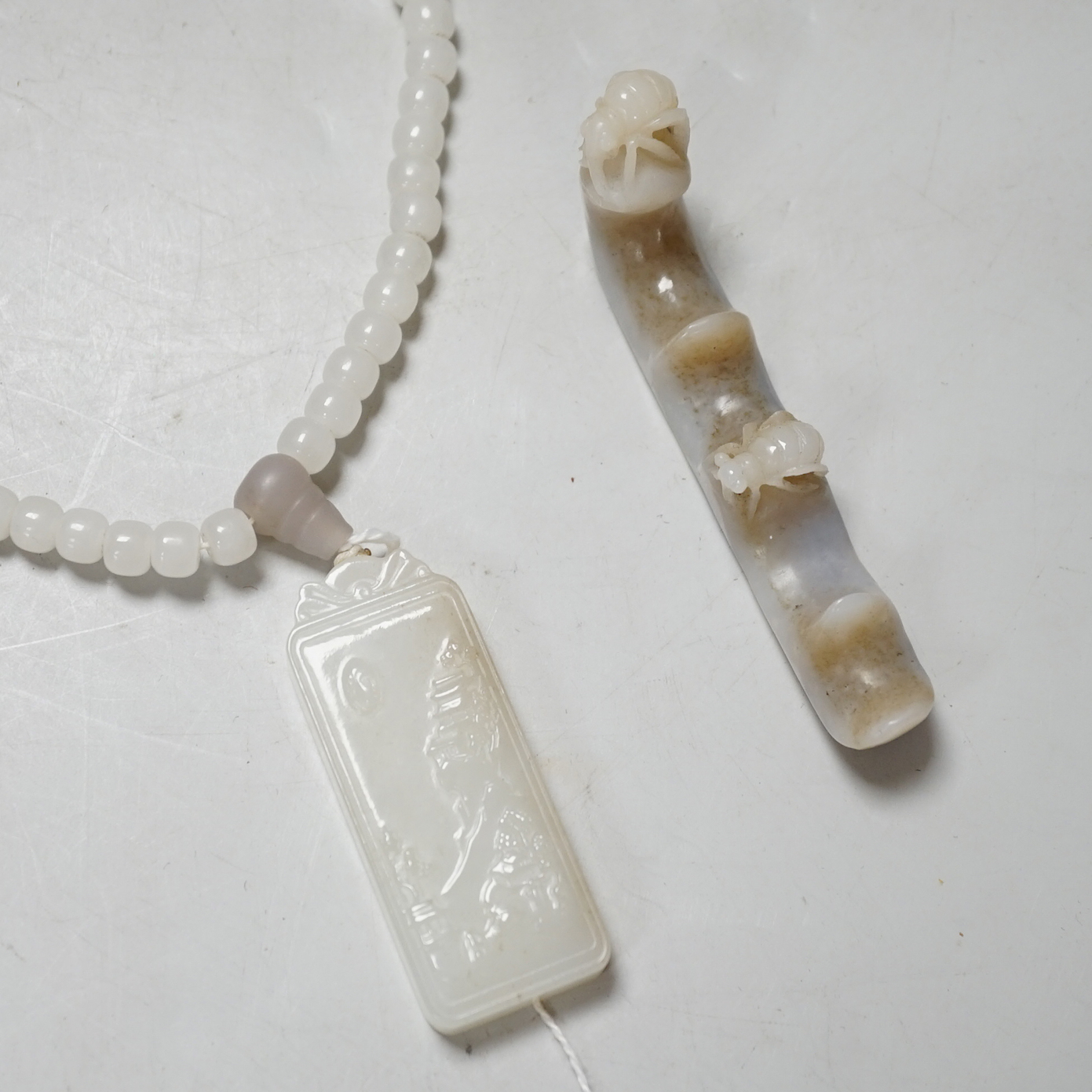 A Chinese white jade pendant and a jade brush rest                                                                                                                                                                          