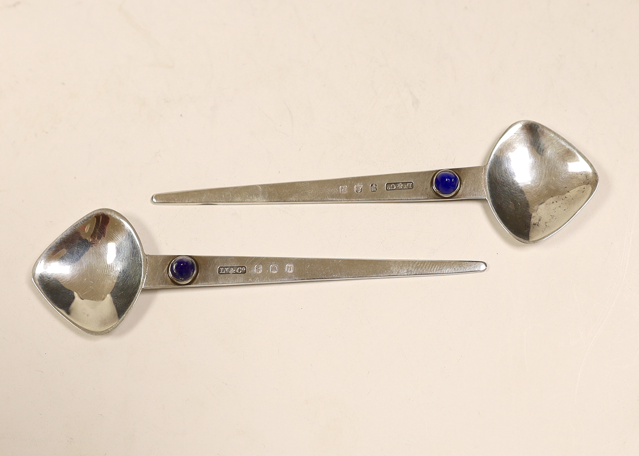 A pair of Elizabeth II Arts & Crafts Scottish silver and single stone cabochon lapis lazuli set spoons, by Liberty & Co, Edinburgh, 1987, 10.4cm.                                                                           