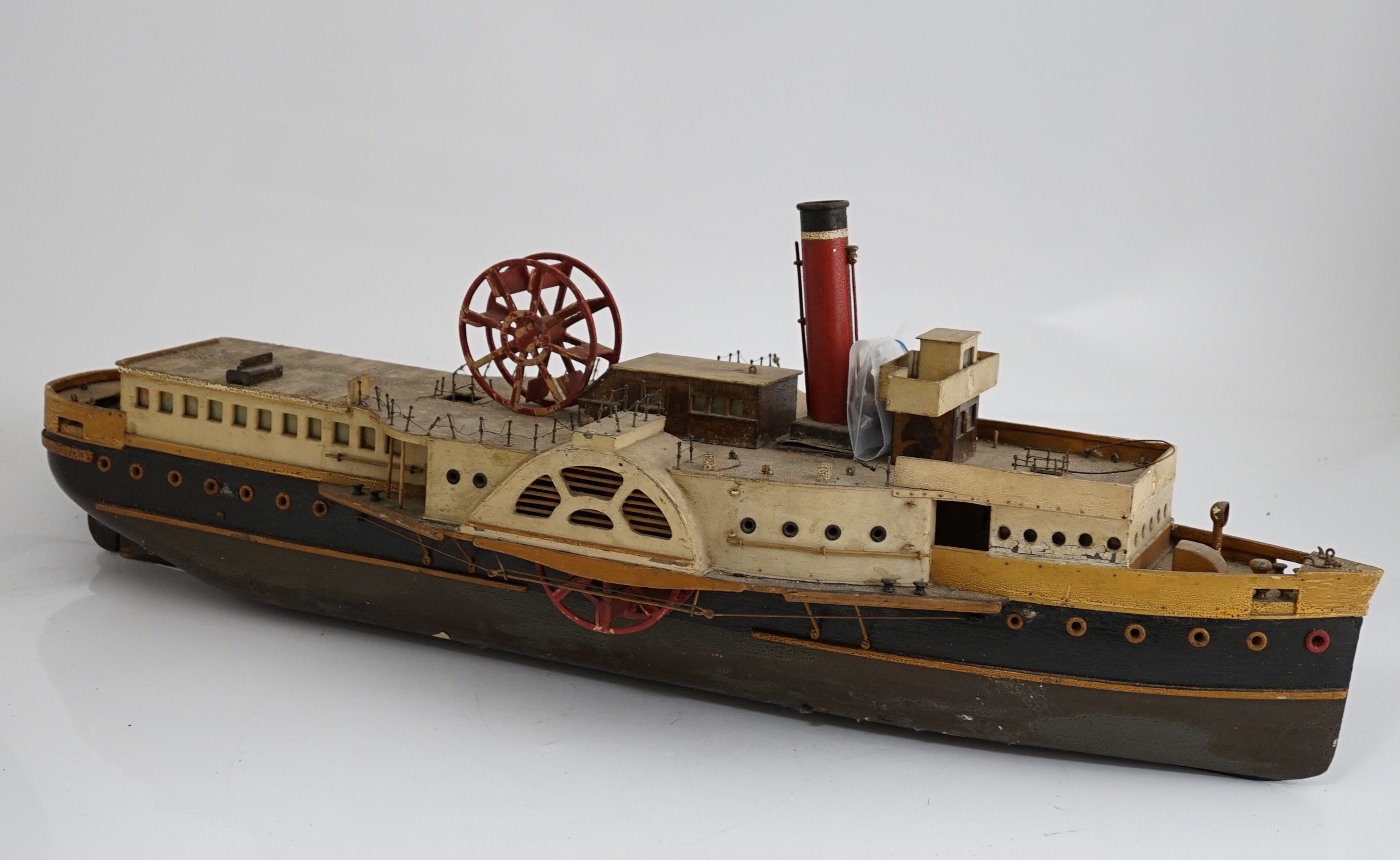 A wooden model of a paddle steamer, with a well detailed deck and with some age to the model, however now requiring some restoration, 80cm long                                                                             