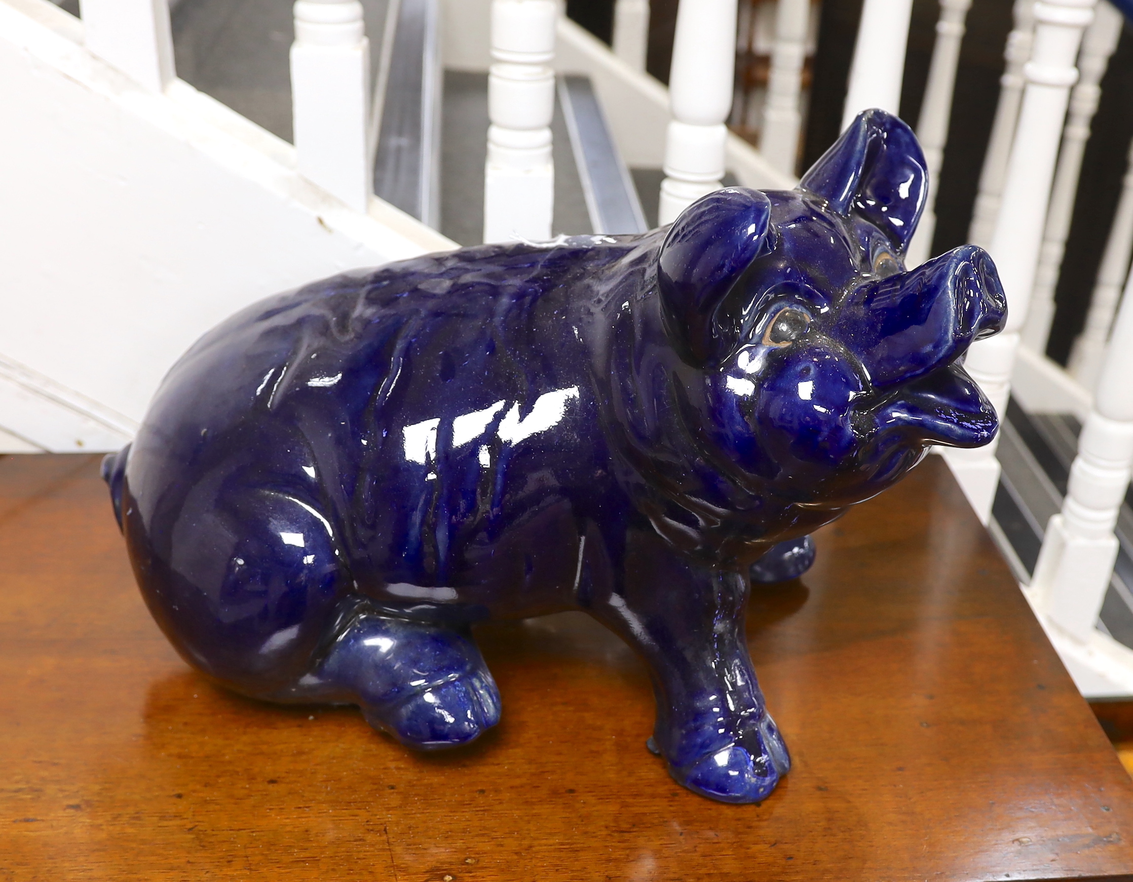 A large seated blue glazed pottery pig, 53cms wide                                                                                                                                                                          