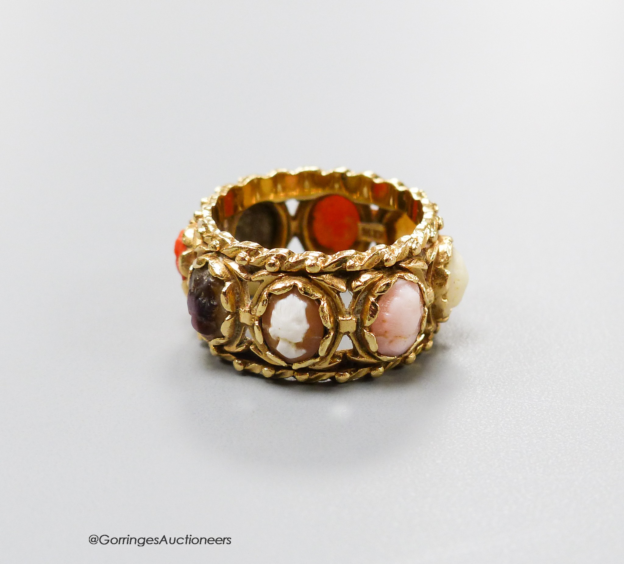 A 14kt yellow metal and multi cameo stone set eternity ring, including shell and coral, size P, gross weight 9.2 grams.                                                                                                     