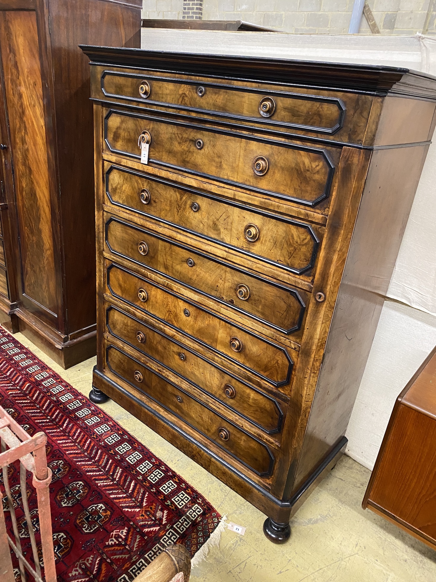 A 19th century French walnut seven drawer chest, with side locking bar, width 127cm, depth 57cm, height 167cm                                                                                                               