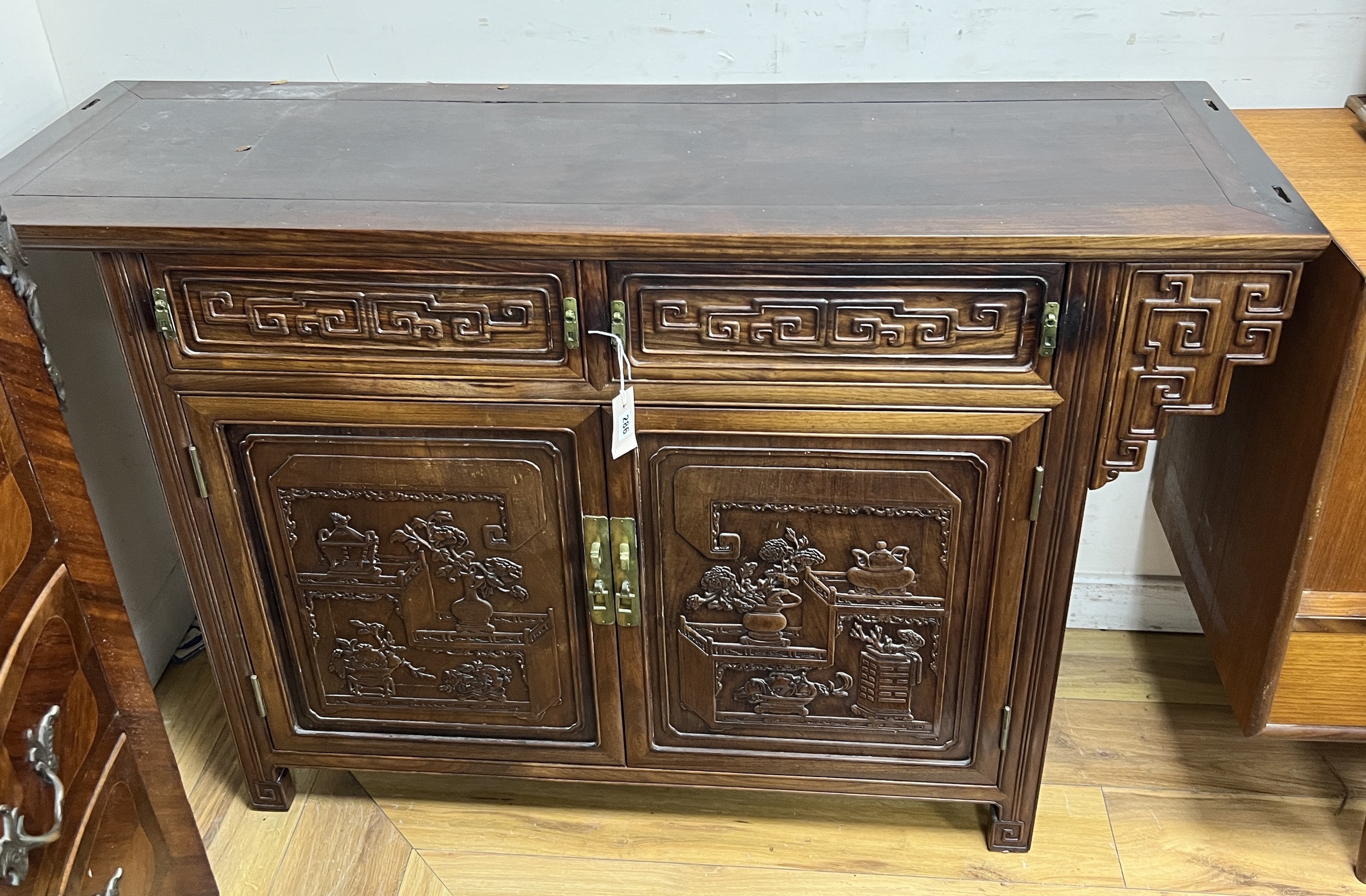 An Asian hardwood side cabinet, width 134cm, depth 44cm, height 84cm                                                                                                                                                        