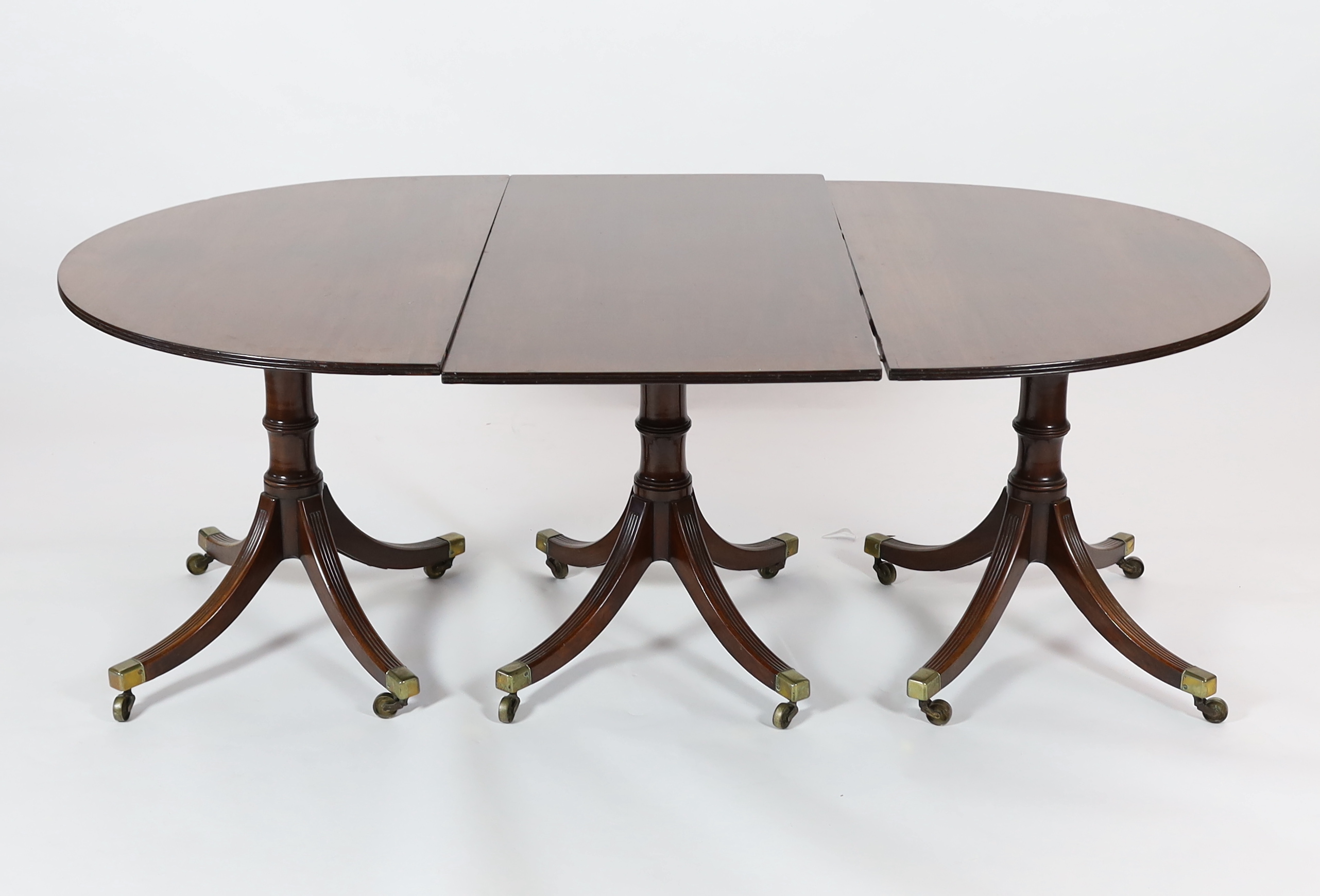 A George III style mahogany triple pillar D end extending dining table in the manner of Gillows                                                                                                                             