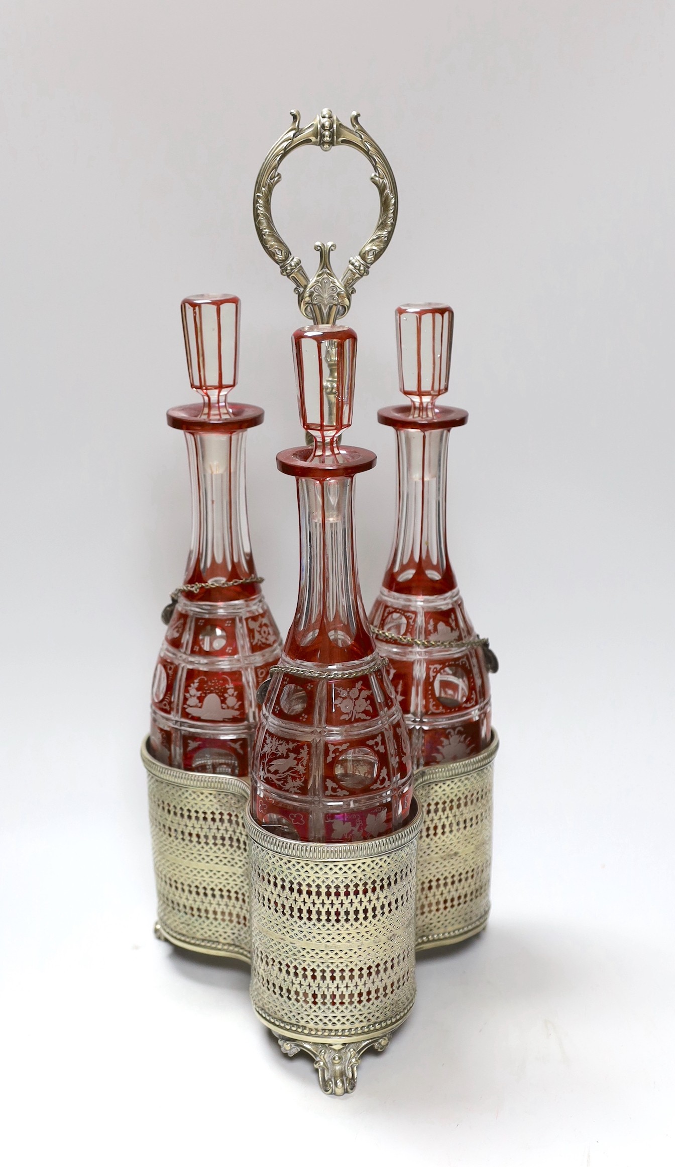 A Victorian three bottle ruby flashed glass and electroplate decanter stand, overall 46cms high                                                                                                                             