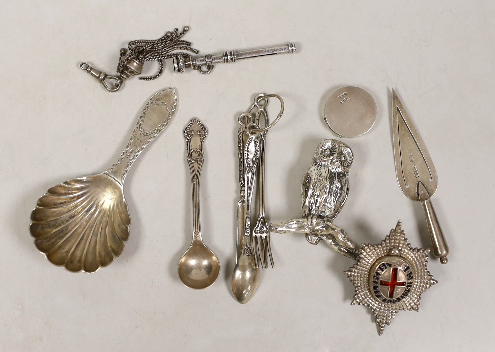 Sundry small silver etc, including a George V silver caddy spoon, a white metal badge, small cutlery and a plated owl.                                                                                                      
