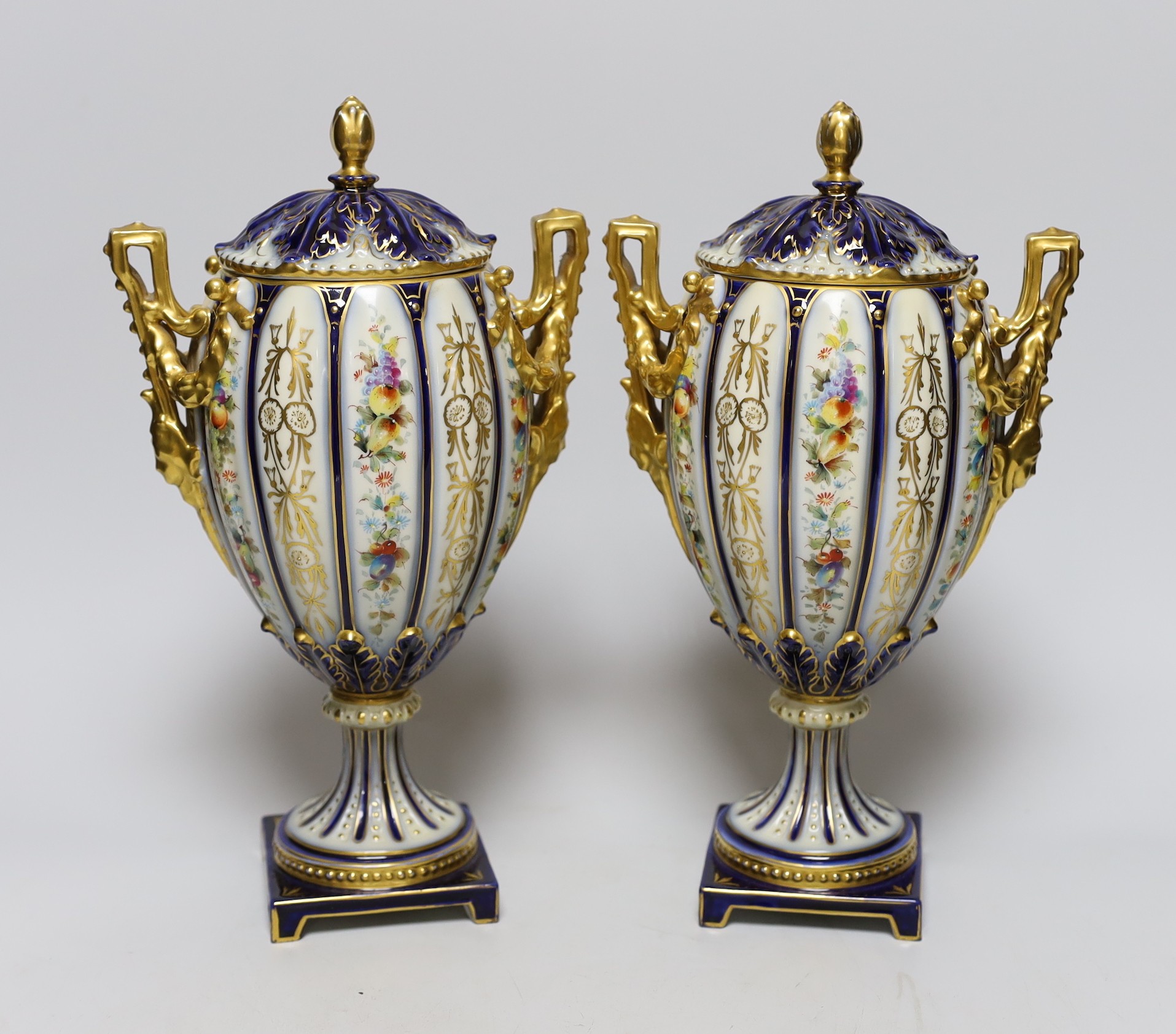 A pair of 19th century continental porcelain gilt and floral urns and covers, 29cms high                                                                                                                                    