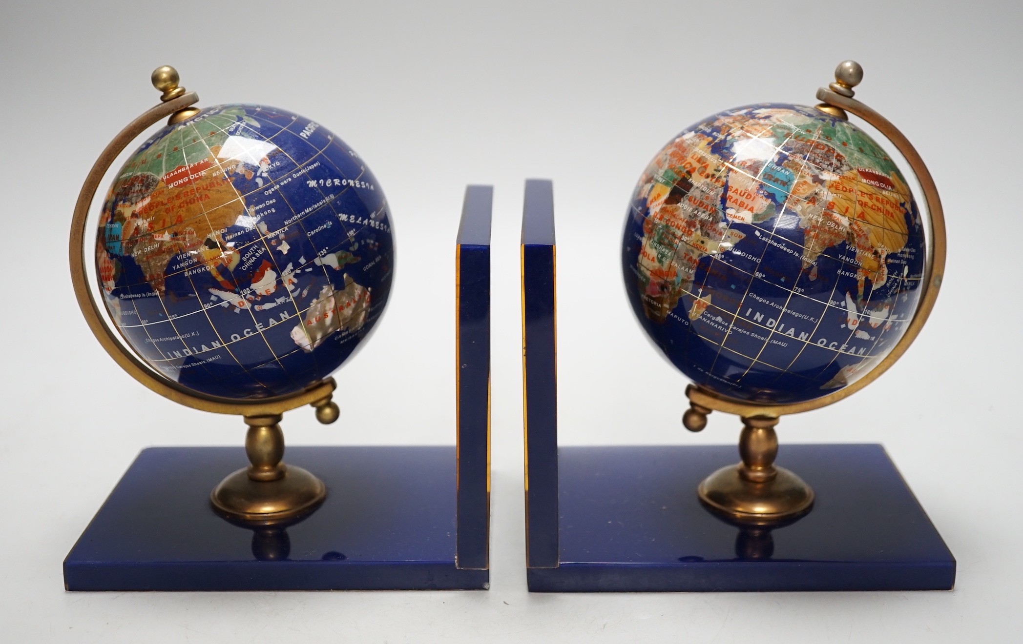 A pair of hardstone mounted acrylic ‘terrestrial globe’ bookends. 18cm tall                                                                                                                                                 