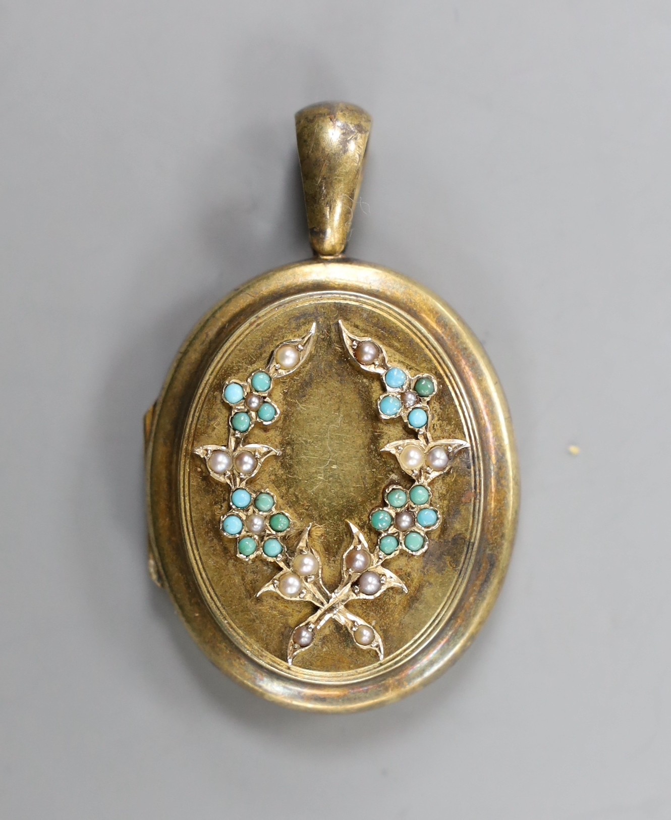 A late Victorian yellow metal, turquoise and seed pearl set oval locket, overall 48mm, gross weight 16.2 grams.                                                                                                             