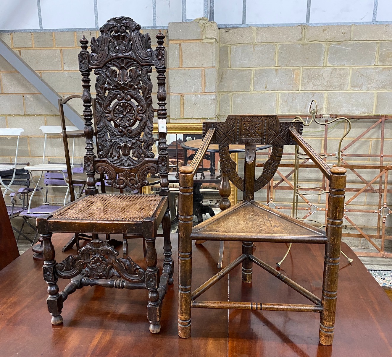A Carolean style carved oak cane seat highback dining chair together with a chip carved oak chair with triangular seat                                                                                                      
