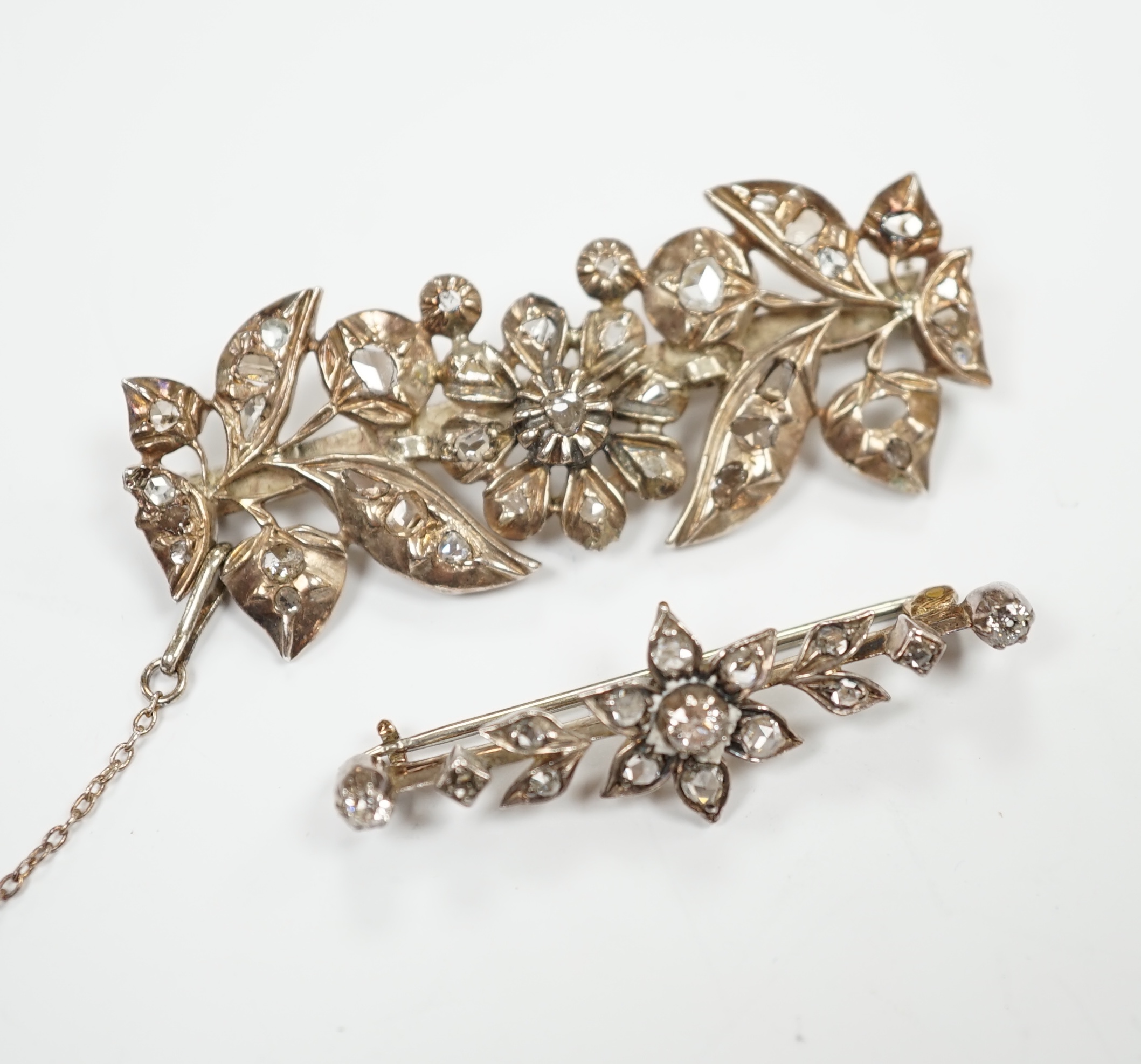 Two early 20th century yellow and white metal, rose cut diamond set foliate brooches, largest 51mm, gross weight 13.9 grams.                                                                                                