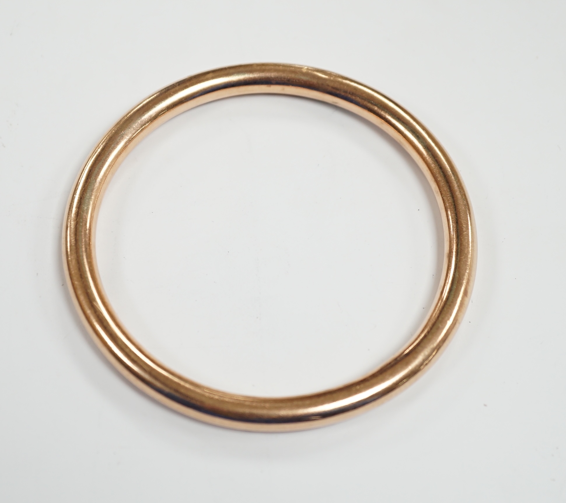 A George V 9ct gold hollow bangle, interior diameter 67mm, 13.8 grams.                                                                                                                                                      
