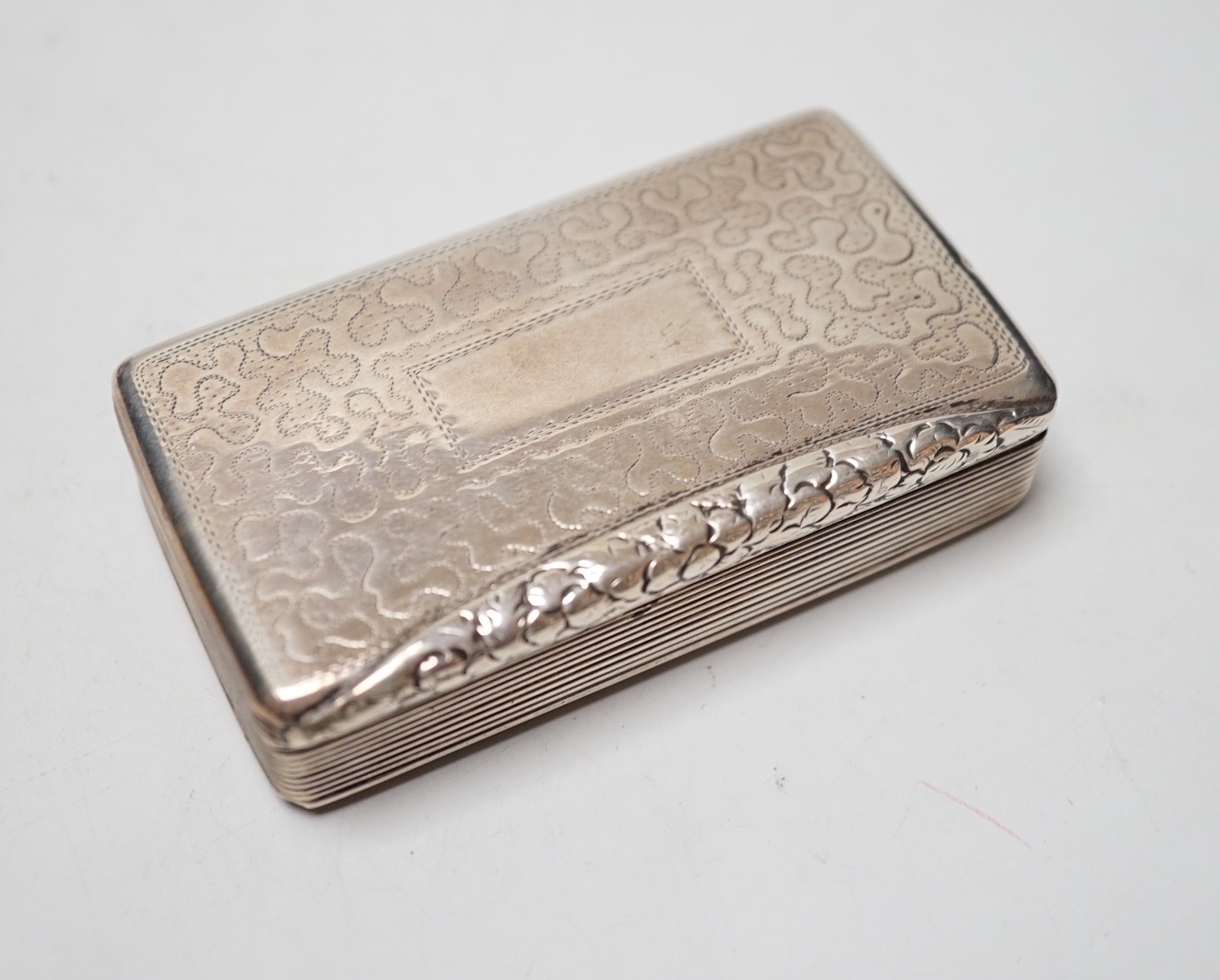 A late George IV engraved silver rectangular snuff box, with wriggle work decoration, William Simpson, Birmingham, 1829, 81mm.                                                                                              