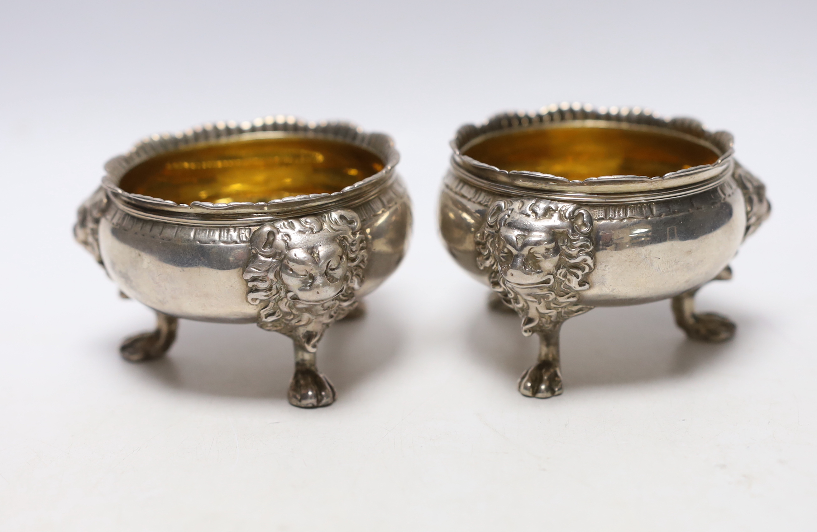 A pair of George II silver bun salts, with lion mask knees, on paw feet, maker's mark rubbed, London, 1736, diameter 70mm, 11.9oz.                                                                                          