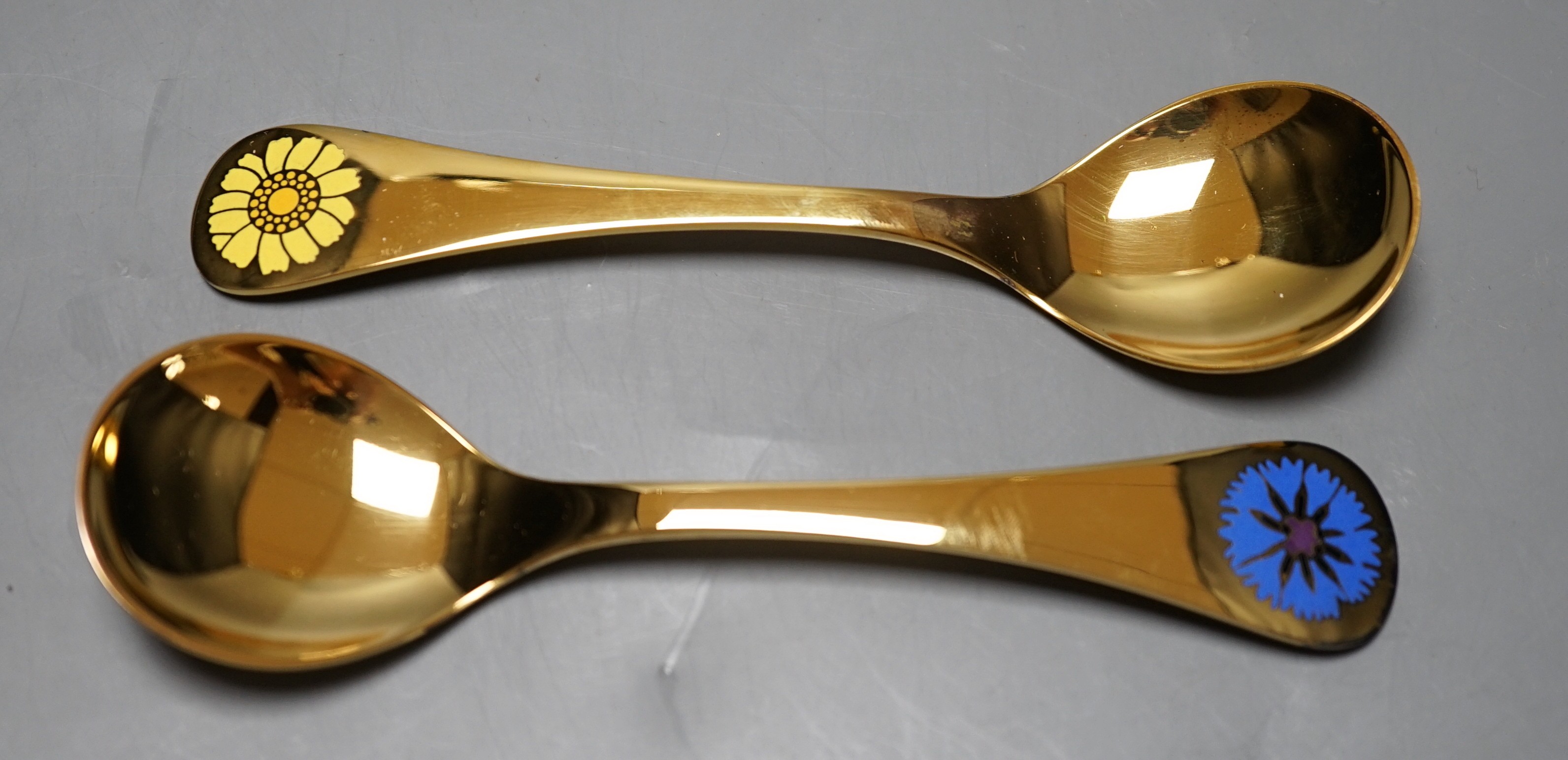 A Georg Jensen gilt sterling 1972 'Cornflower' spoon, 14.9cm and a similar Georg Jensen 1973 spoon, with box or pouch.                                                                                                      