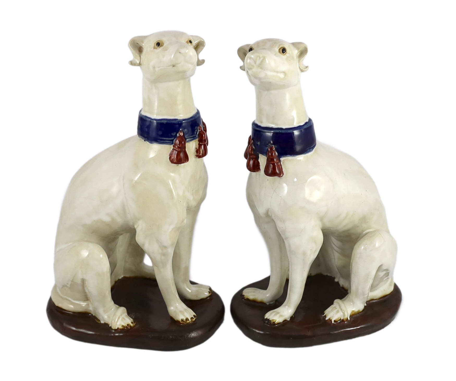 A pair of Italian tin-glaze earthenware figures of seated greyhounds, 35cm high                                                                                                                                             